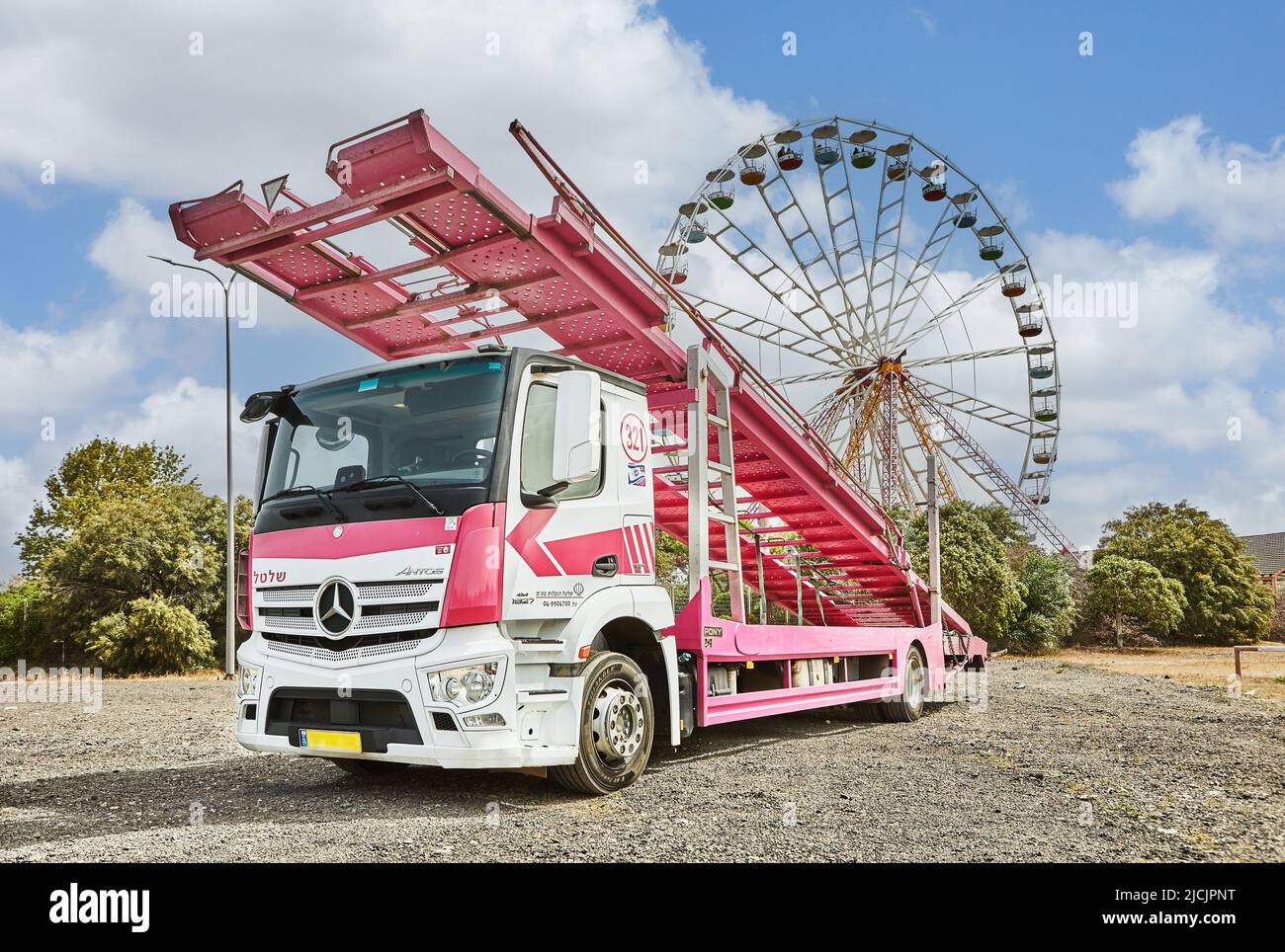 Mercedes Truck pour le transport de voitures neuves sur fond de parc d'attractions. Banque D'Images