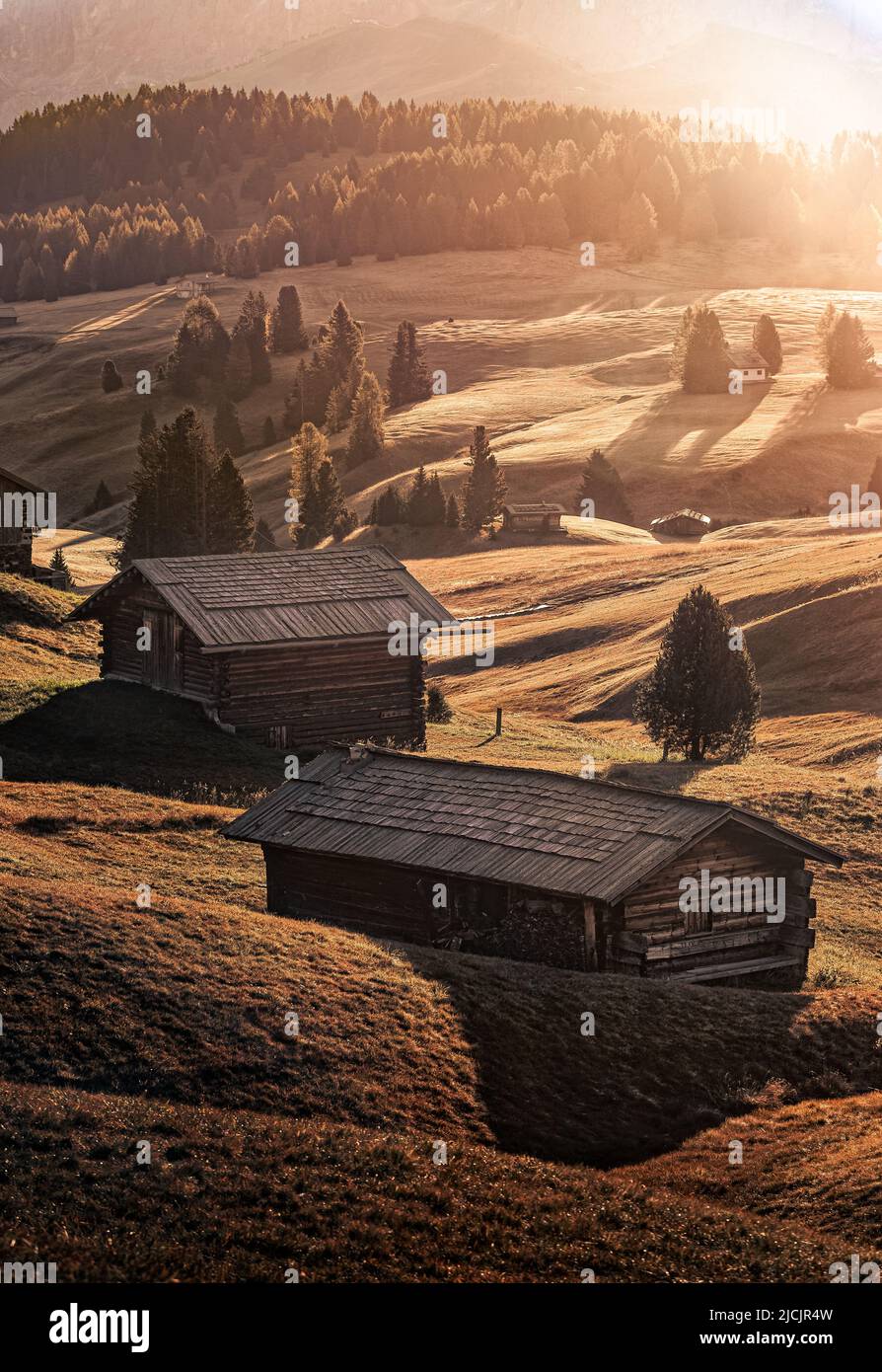 Alpe di Siusi, Italie - cabines traditionnelles en bois à Seiser Alm, une prairie alpine au lever du soleil d'automne aux Dolomites italiennes, dans le Tyrol du Sud Banque D'Images