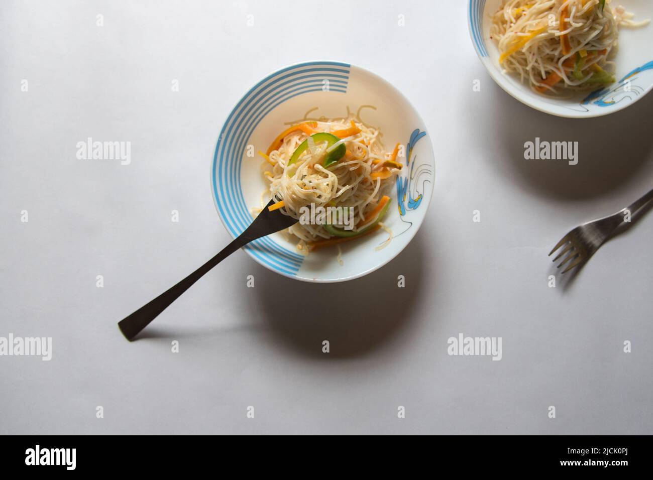 Nouilles frites servies dans un bol sur fond. Vue de dessus, mise au point sélective. Banque D'Images