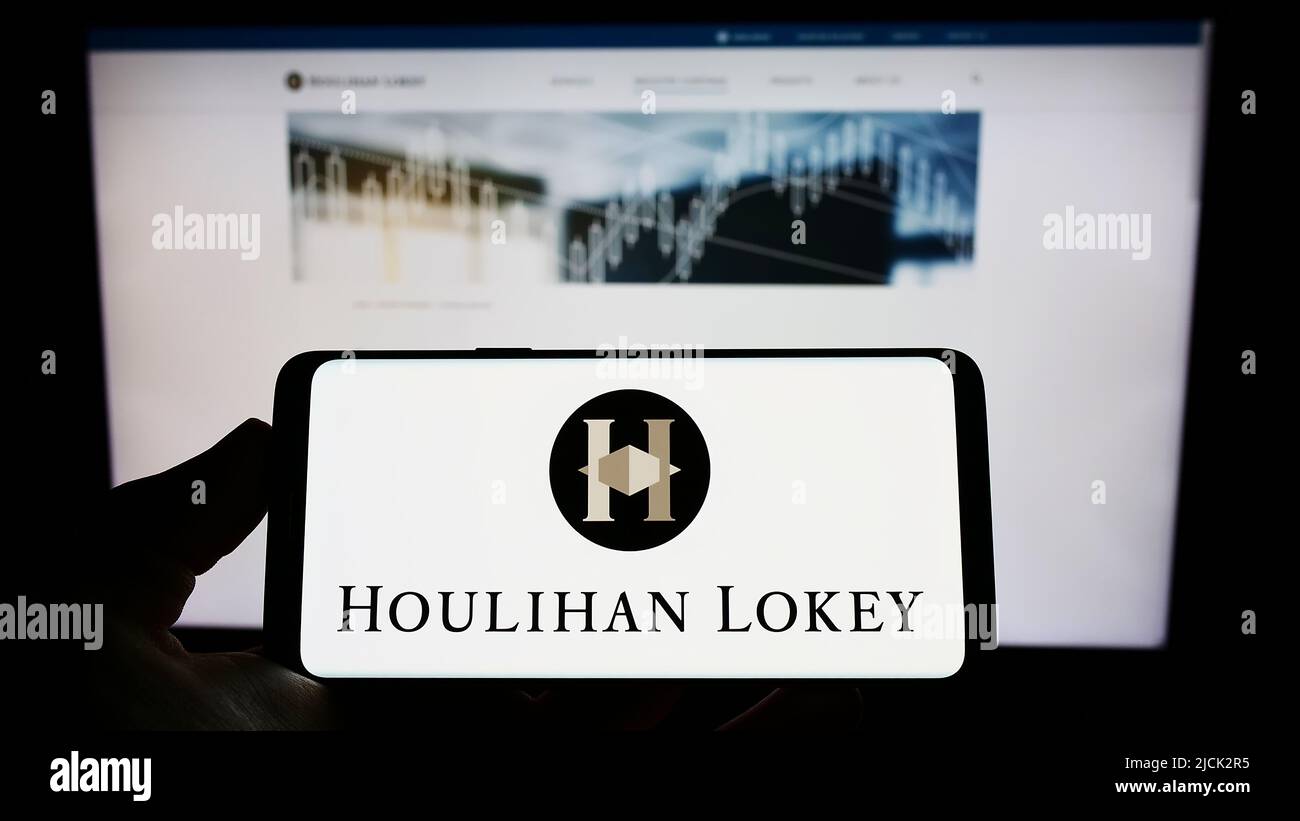 Personne tenant un smartphone avec le logo de la société d'investissement américaine Houlihan Lokey Inc. À l'écran devant le site Web. Mise au point sur l'affichage du téléphone. Banque D'Images