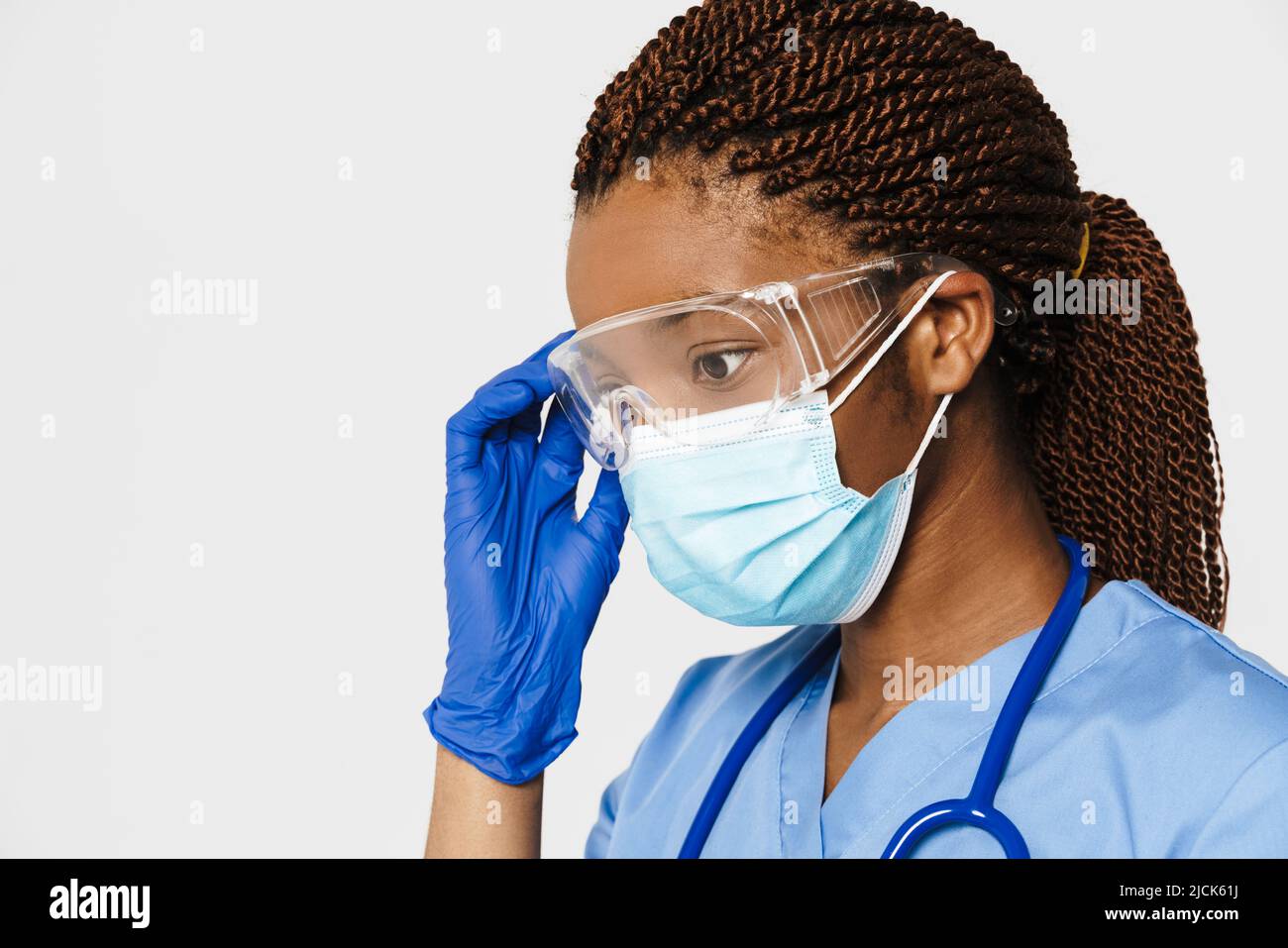 Médecin noir portant un masque posé dans des lunettes de sécurité isolées sur fond blanc Banque D'Images