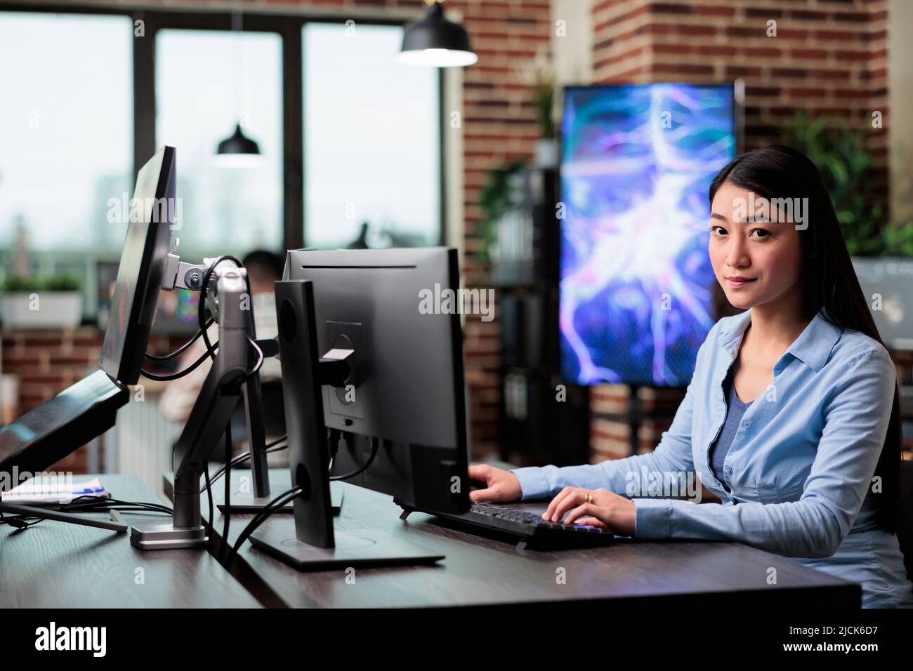 Bureau de l'entreprise travailleur professionnel confiant assis dans l'espace de travail en utilisant le bureau de l'ordinateur pour créer des graphiques. Employé de l'agence créative travaillant à développer un projet numérique tout en étant assis à son bureau. Banque D'Images