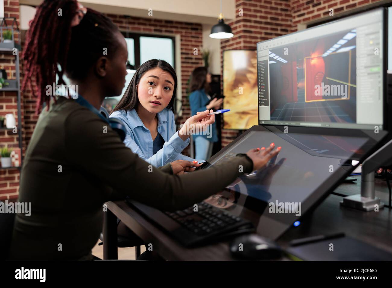 Videogame en développement des employés de la société travaillant sur la construction alpha du projet de jeu 3D tout en étant assis à un bureau. Département de production divers membres de l'équipe optimisant les produits numériques à l'aide de logiciels modernes. Banque D'Images