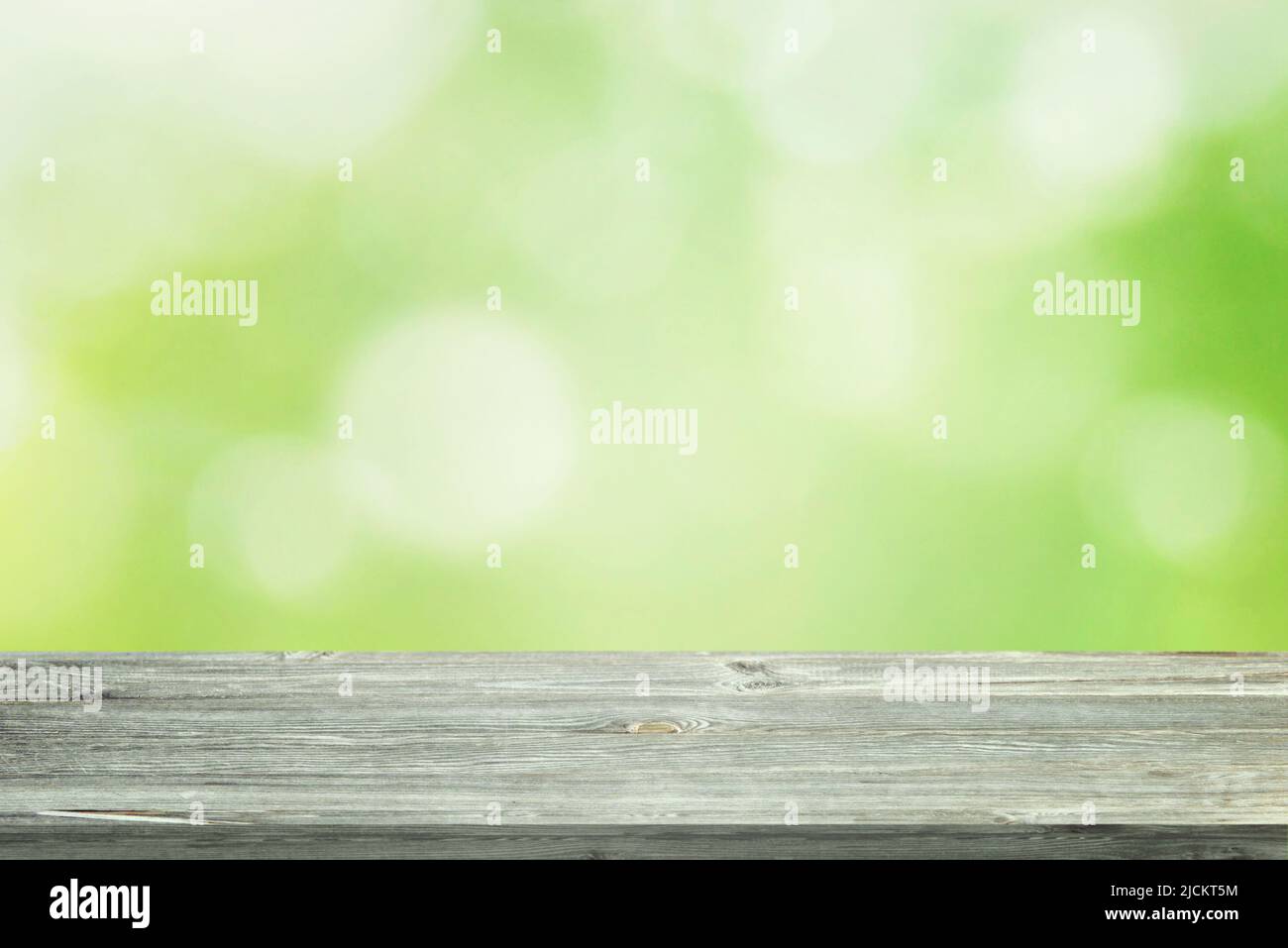 Bureau de travail en bois avec fond vert nature. Nettoyer le socle pour la présentation du produit Banque D'Images