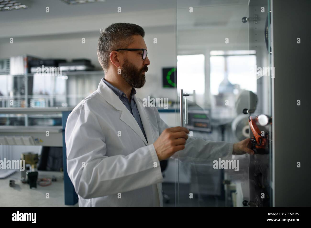 Ingénieur en robotique travaillant sur le détage d'un bras robotique moderne en laboratoire. Banque D'Images