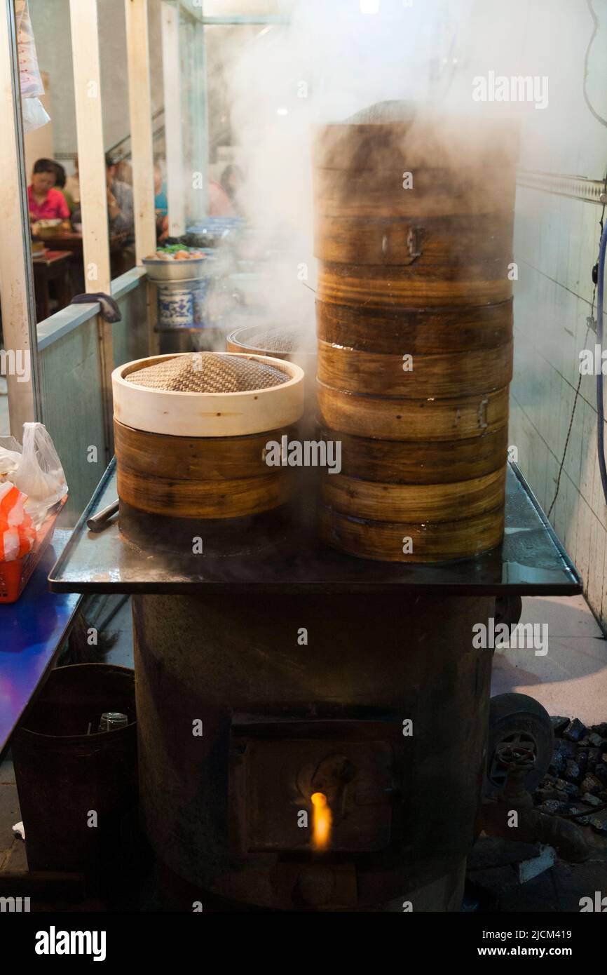Les cuiseurs à vapeur de riz au bambou empilables cuisent des aliments tels que du riz, des légumes, des légumes, des boulettes, Ou dim sum sur l'eau bouillante et une flamme vivante feu Xi'anStackable riz vapeur de riz de bambou aliments tels que le riz, légumes, légumes, boulettes, riz collant, boulettes, ou dim sum sur l'eau bouillante et un feu de flamme vivant. Un restaurant local dans la ville de Xi'an, RPC. Chine. (125) Banque D'Images