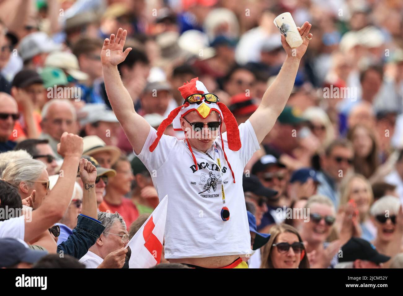 Une Angleterre fan d'une pinte de bière en une seule fois alors qu'il est pris par toute la foule Banque D'Images