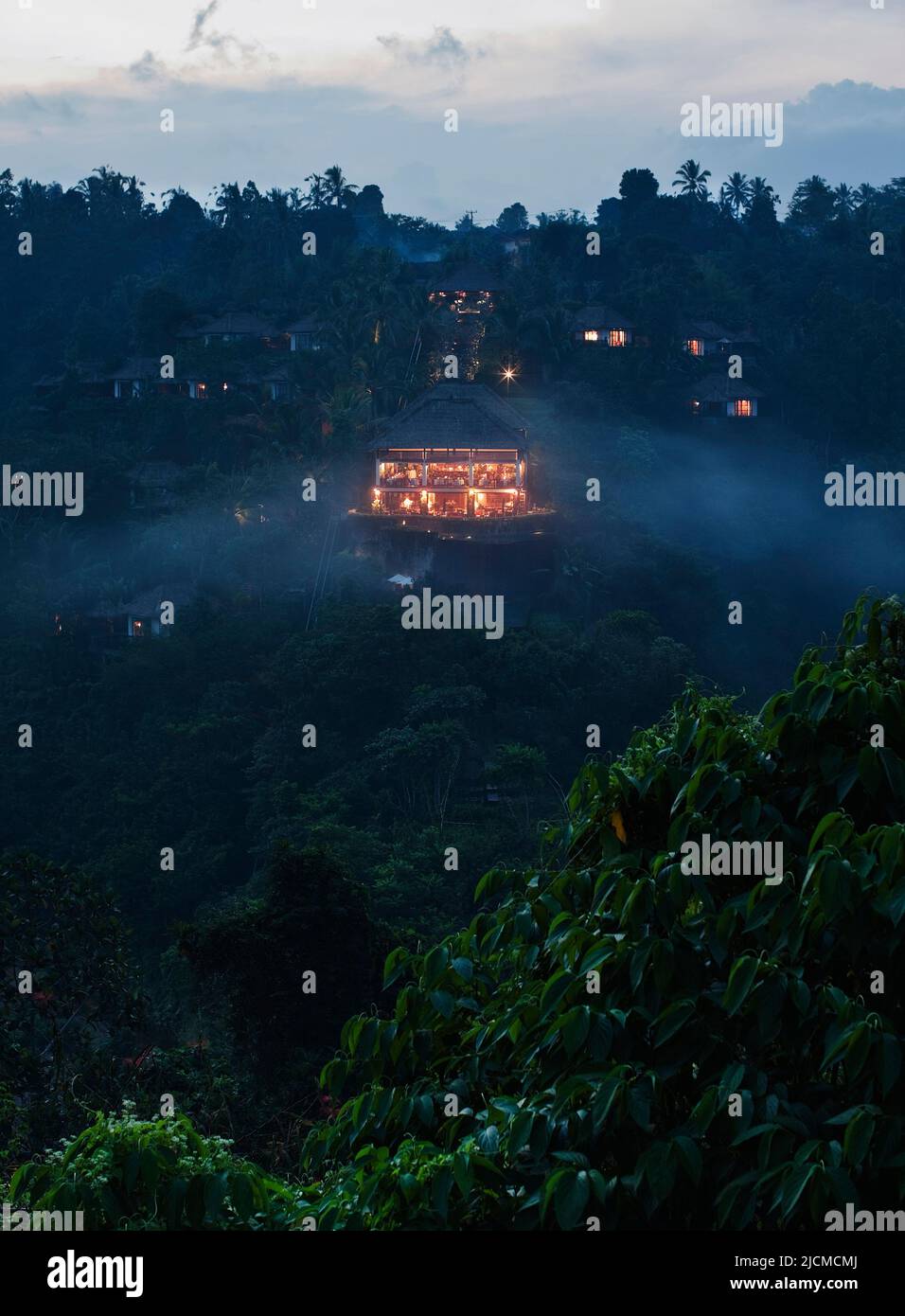 Vue sur le restaurant Béduur au crépuscule de l'autre côté de la vallée de la rivière Ayung, jardins suspendus d'Ubud, Bali, Indonésie. Banque D'Images