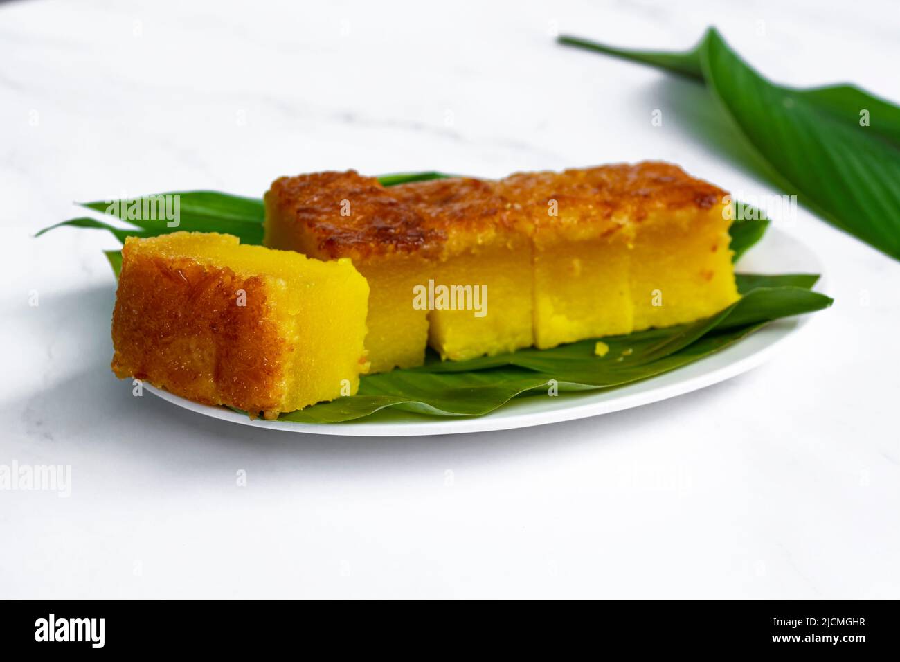Dessert et encas populaires et traditionnels de Malaisie sur une assiette. Kuih Bingka UBI ou gâteau au tapioca cuit au four Banque D'Images