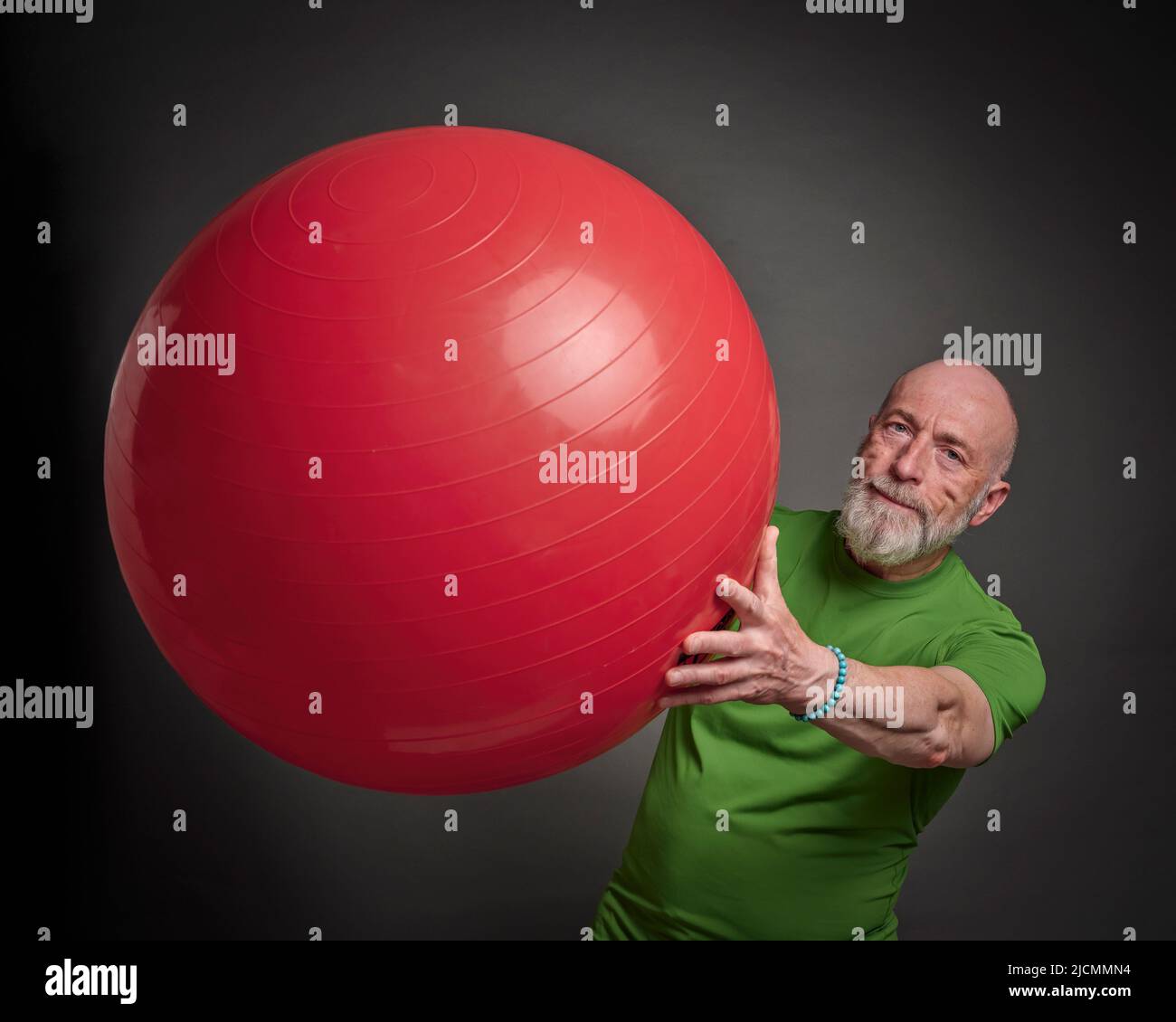 L'homme senior (fin 60s) s'exerce avec un grand ballon suisse, une activité et une forme physique plus de 60 concept Banque D'Images