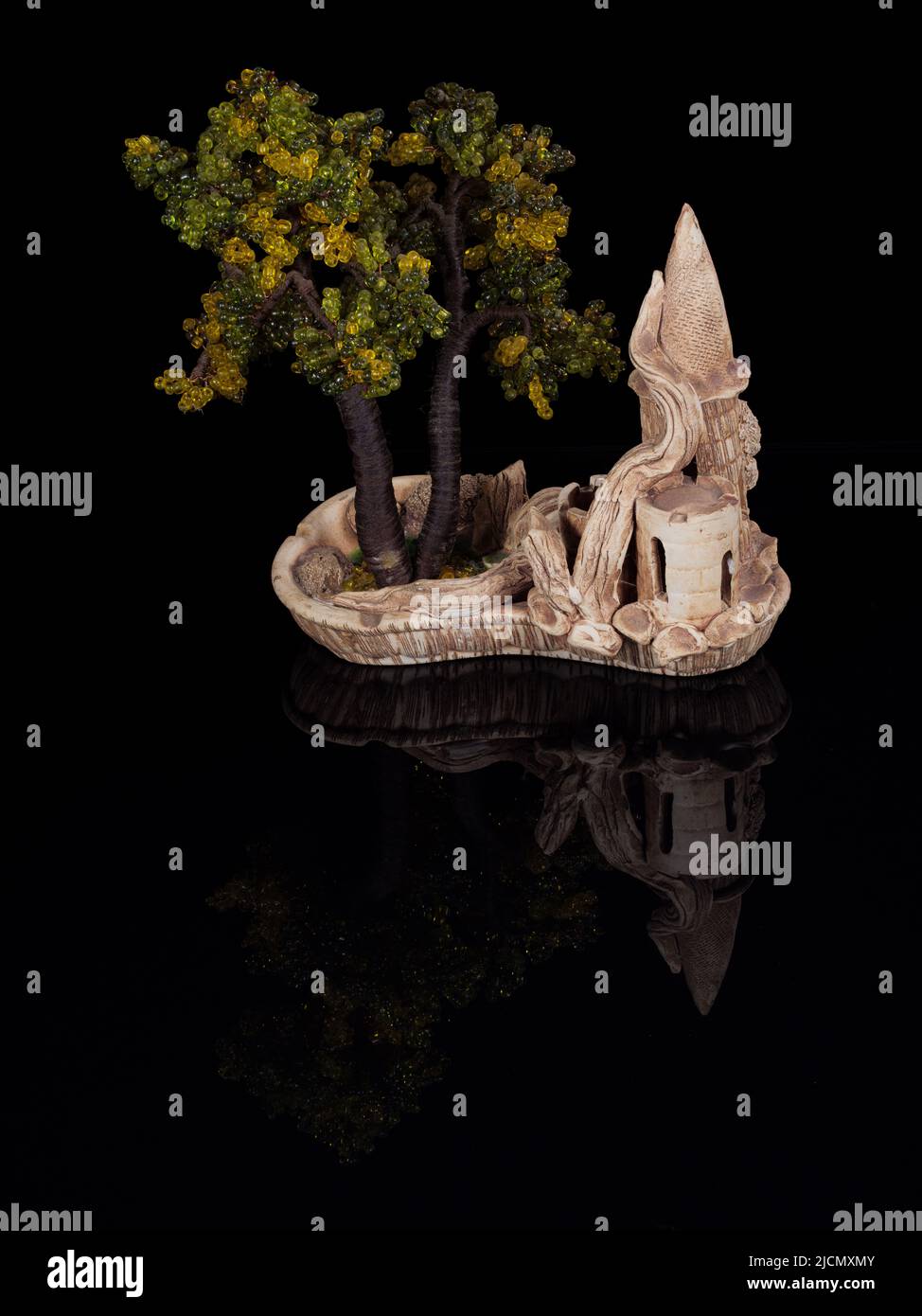 Bonsai arbre miniature dans un pot en céramique isolé sur noir Banque D'Images