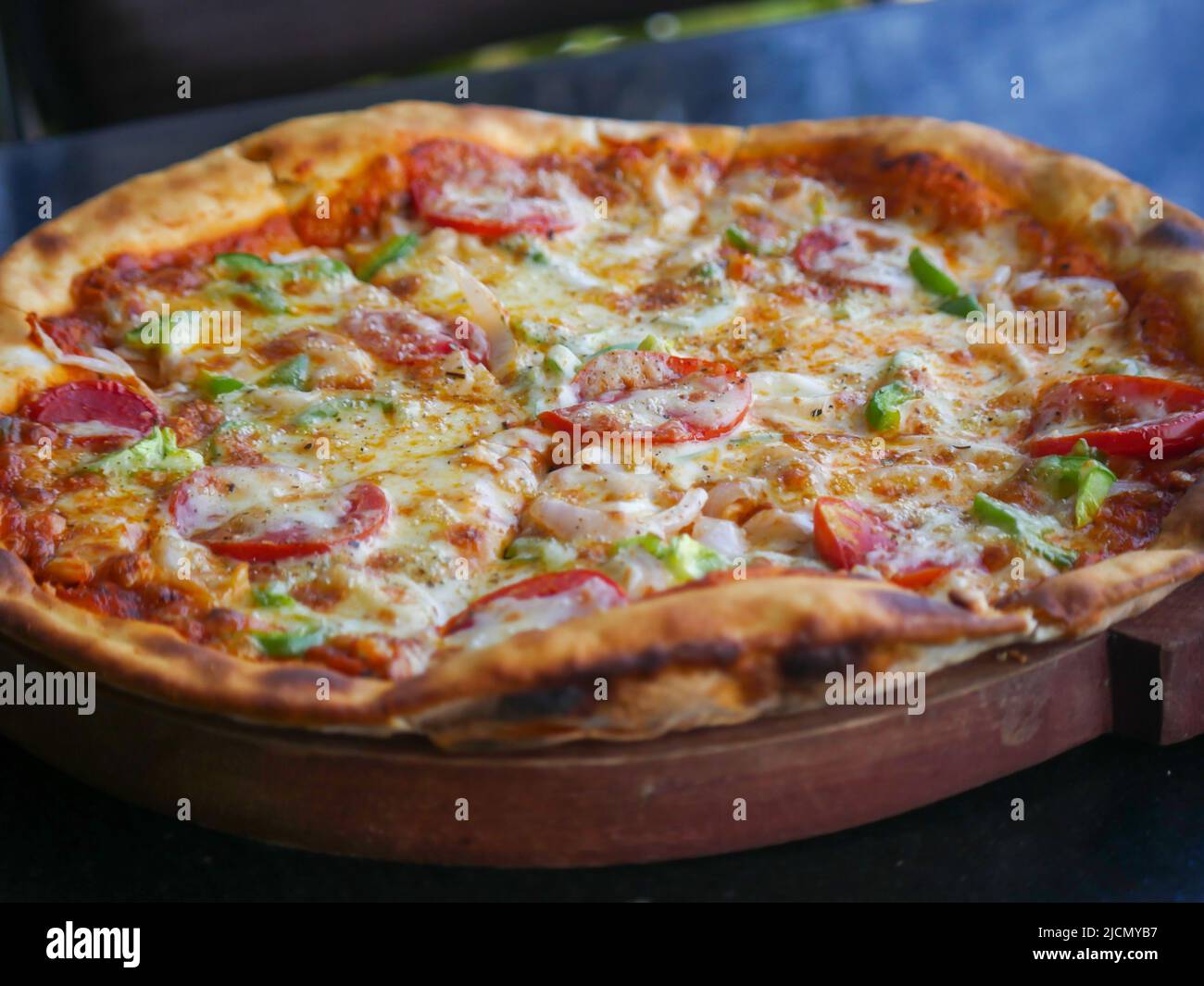 Pizza au fromage végétarien indien, nappée de tomates, de poivrons et d'oignons. Pizza aux légumes en inde Banque D'Images