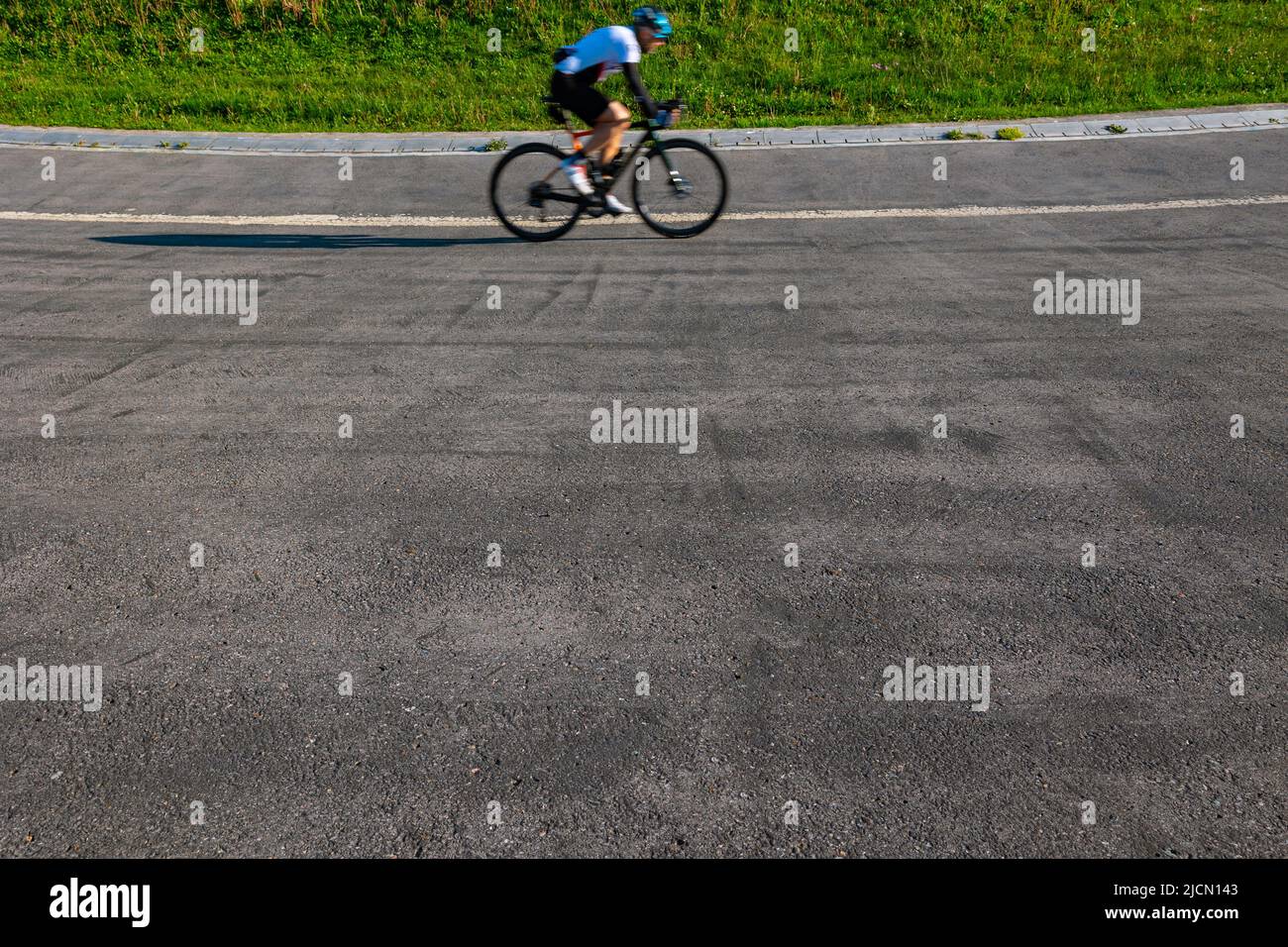 Un entraînement cycliste sur la piste de course dans le parc. Photo de fond de style de vie sain. Flou de mouvement sur le vélo ou les cyclistes. Banque D'Images