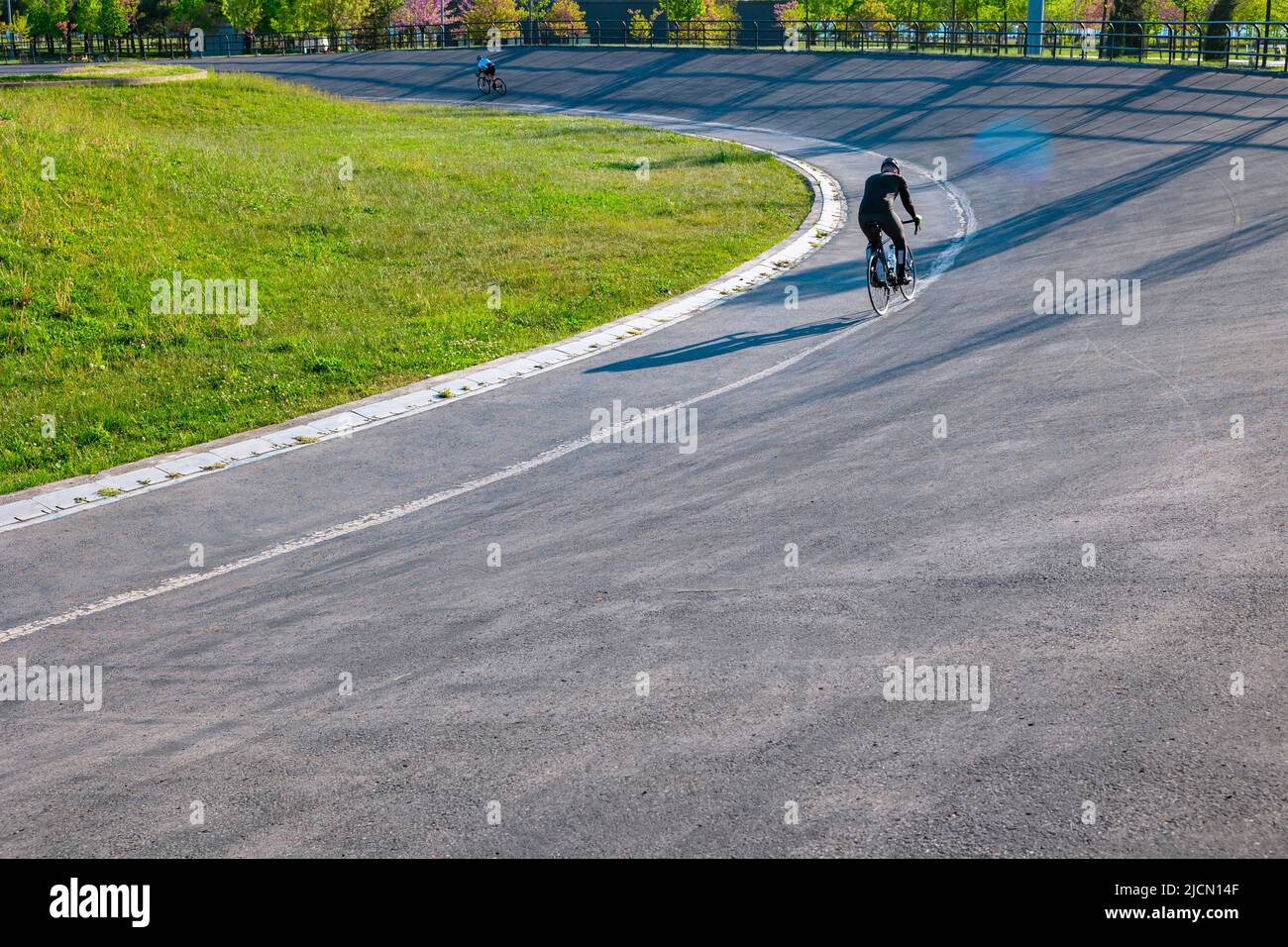 Entraînement cycliste ou cycliste avec un vélo. Piste de course dans le parc. Photo de fond de style de vie sain. Flou de mouvement sur le vélo. Banque D'Images