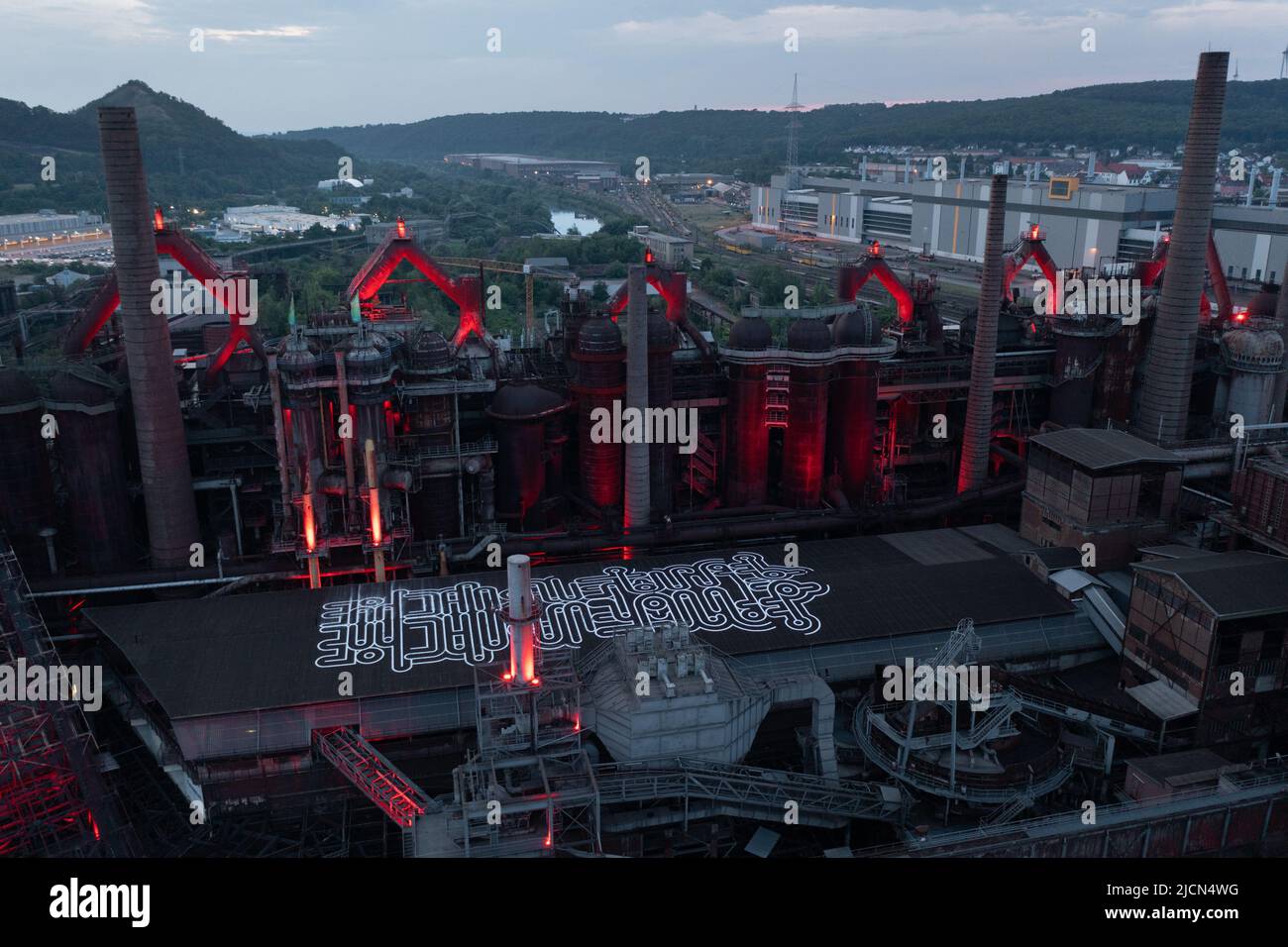 Vue aérienne du site du patrimoine mondial de l'UNESCO de Voelklingen Ironworks rouge avec éclairage rouge nocturne Banque D'Images