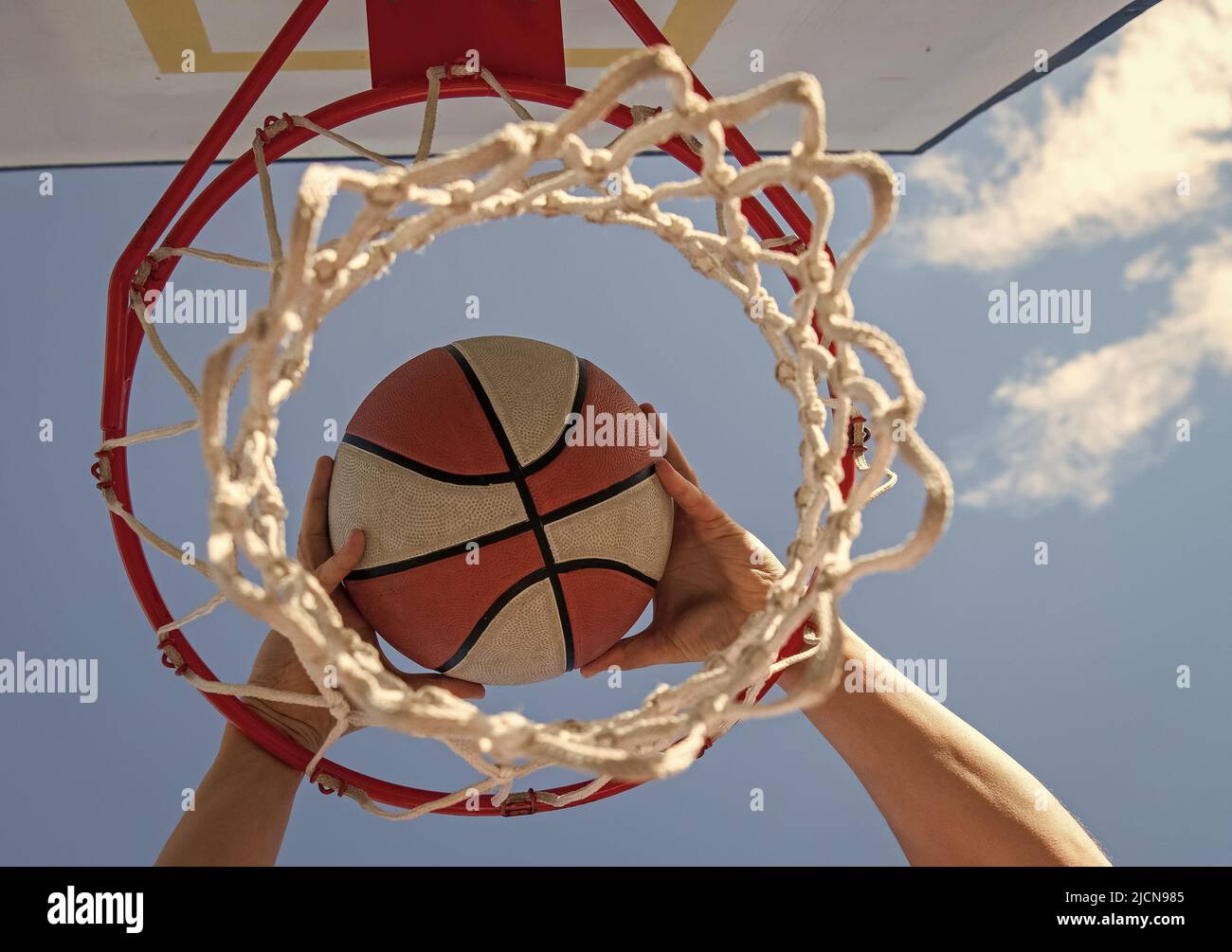 les mains du joueur de basket-ball jette le ballon dans le cerceau, succès Banque D'Images