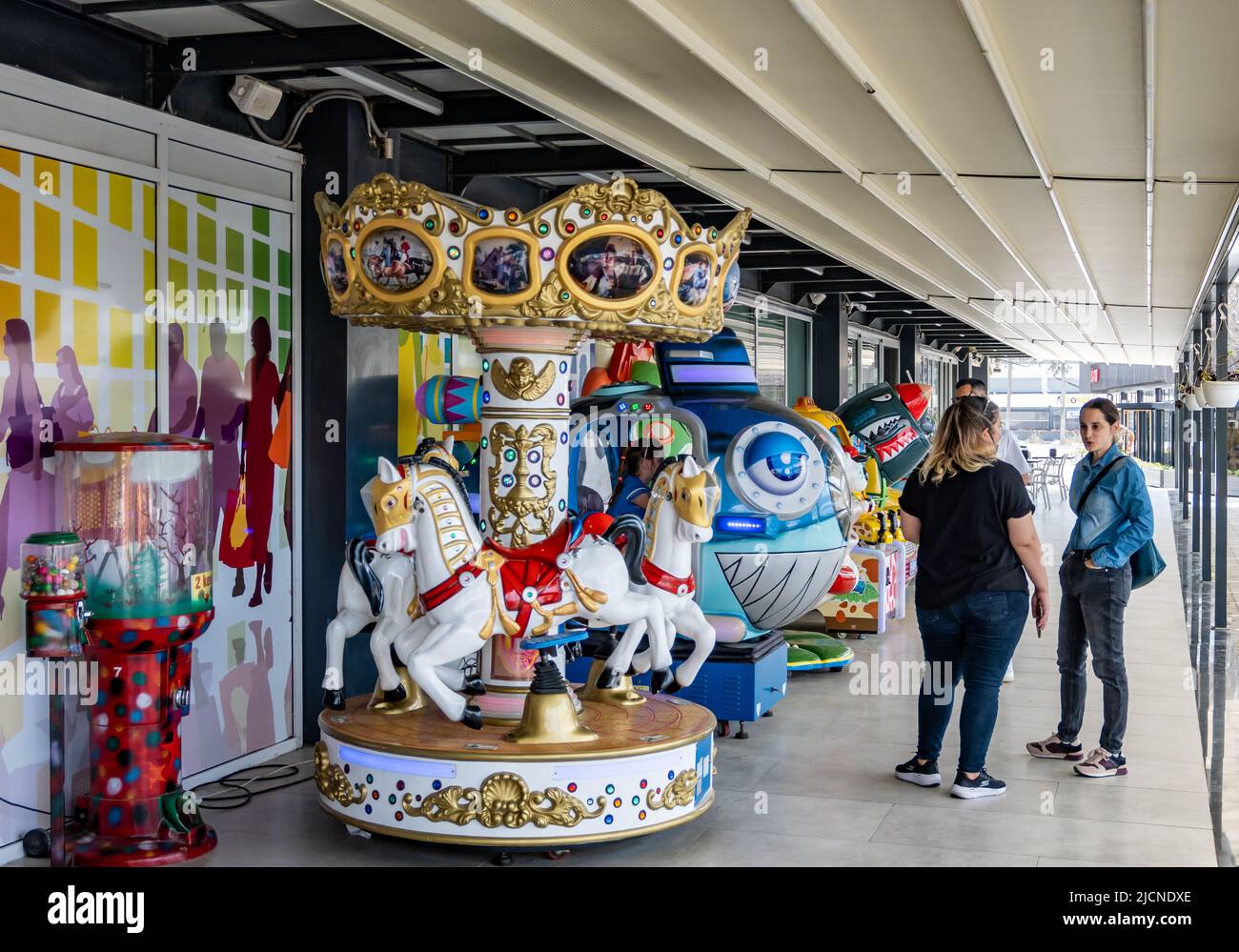 Des manèges colorés pour les enfants en face d'un magasin local. Chypre. Banque D'Images