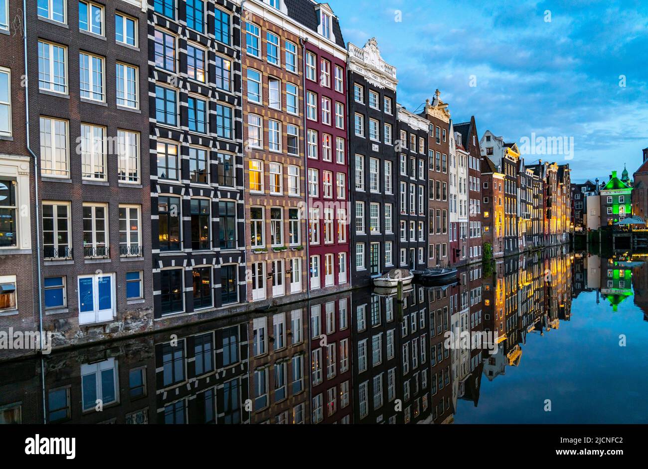 Maisons de canal sur le Damrak, dans le centre de la vieille ville d'Amsterdam, port, point de départ de nombreuses visites de canal, soirée, pays-Bas, Banque D'Images