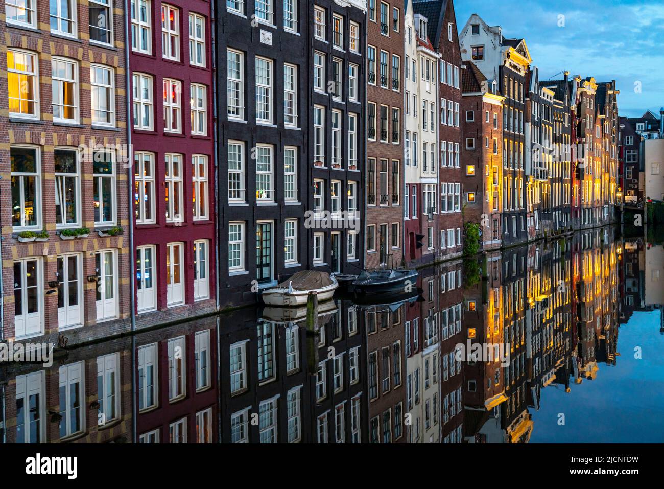 Maisons de canal sur le Damrak, dans le centre de la vieille ville d'Amsterdam, port, point de départ de nombreuses visites de canal, soirée, pays-Bas, Banque D'Images