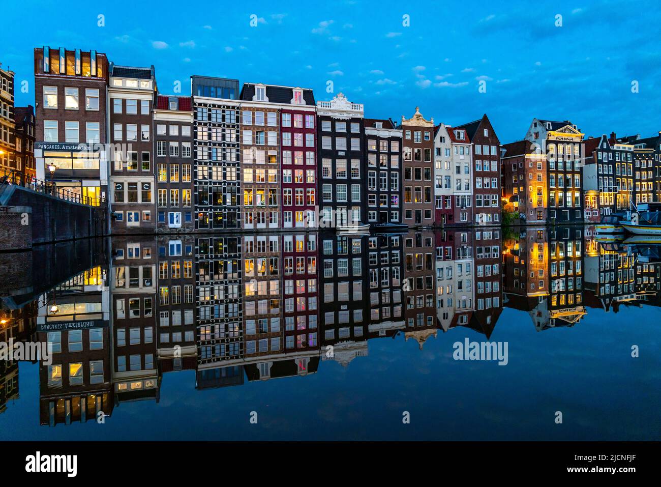 Maisons de canal sur le Damrak, dans le centre de la vieille ville d'Amsterdam, port, point de départ de nombreuses visites de canal, soirée, pays-Bas, Banque D'Images