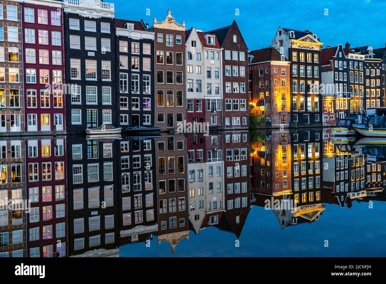 Maisons de canal sur le Damrak, dans le centre de la vieille ville d'Amsterdam, port, point de départ de nombreuses visites de canal, soirée, pays-Bas, Banque D'Images