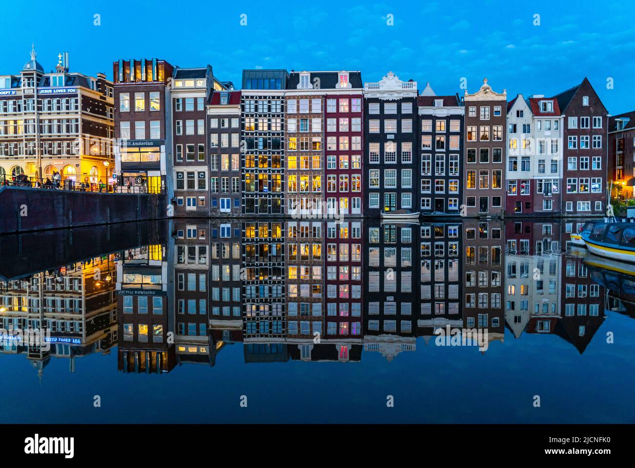 Maisons de canal sur le Damrak, dans le centre de la vieille ville d'Amsterdam, port, point de départ de nombreuses visites de canal, soirée, pays-Bas, Banque D'Images