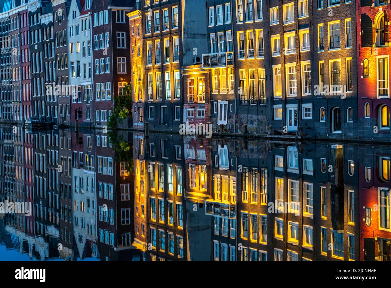 Maisons de canal sur le Damrak, dans le centre de la vieille ville d'Amsterdam, port, point de départ de nombreuses visites de canal, soirée, pays-Bas, Banque D'Images
