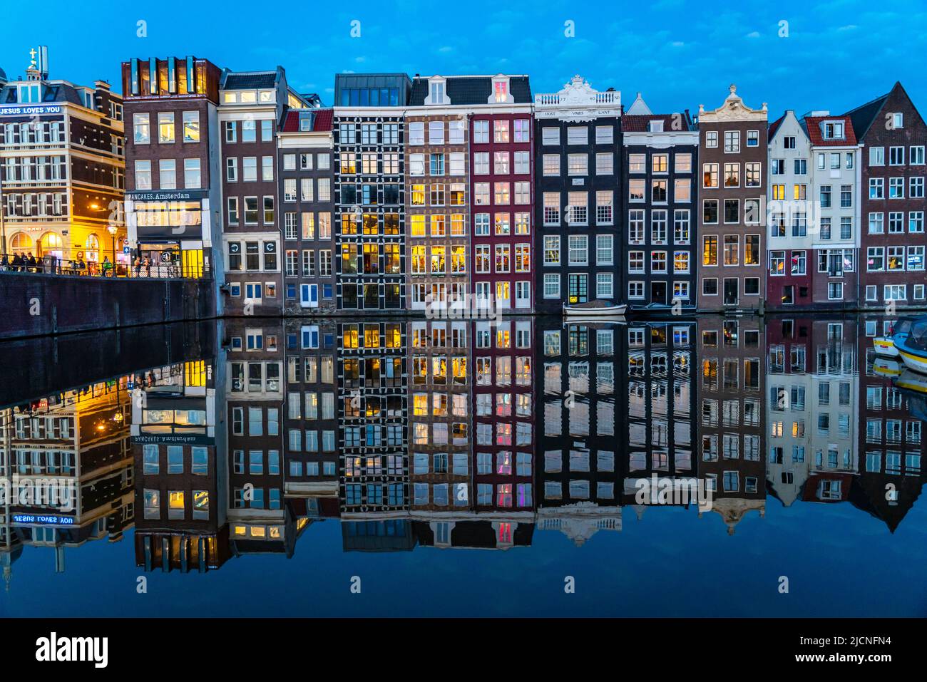 Maisons de canal sur le Damrak, dans le centre de la vieille ville d'Amsterdam, port, point de départ de nombreuses visites de canal, soirée, pays-Bas, Banque D'Images