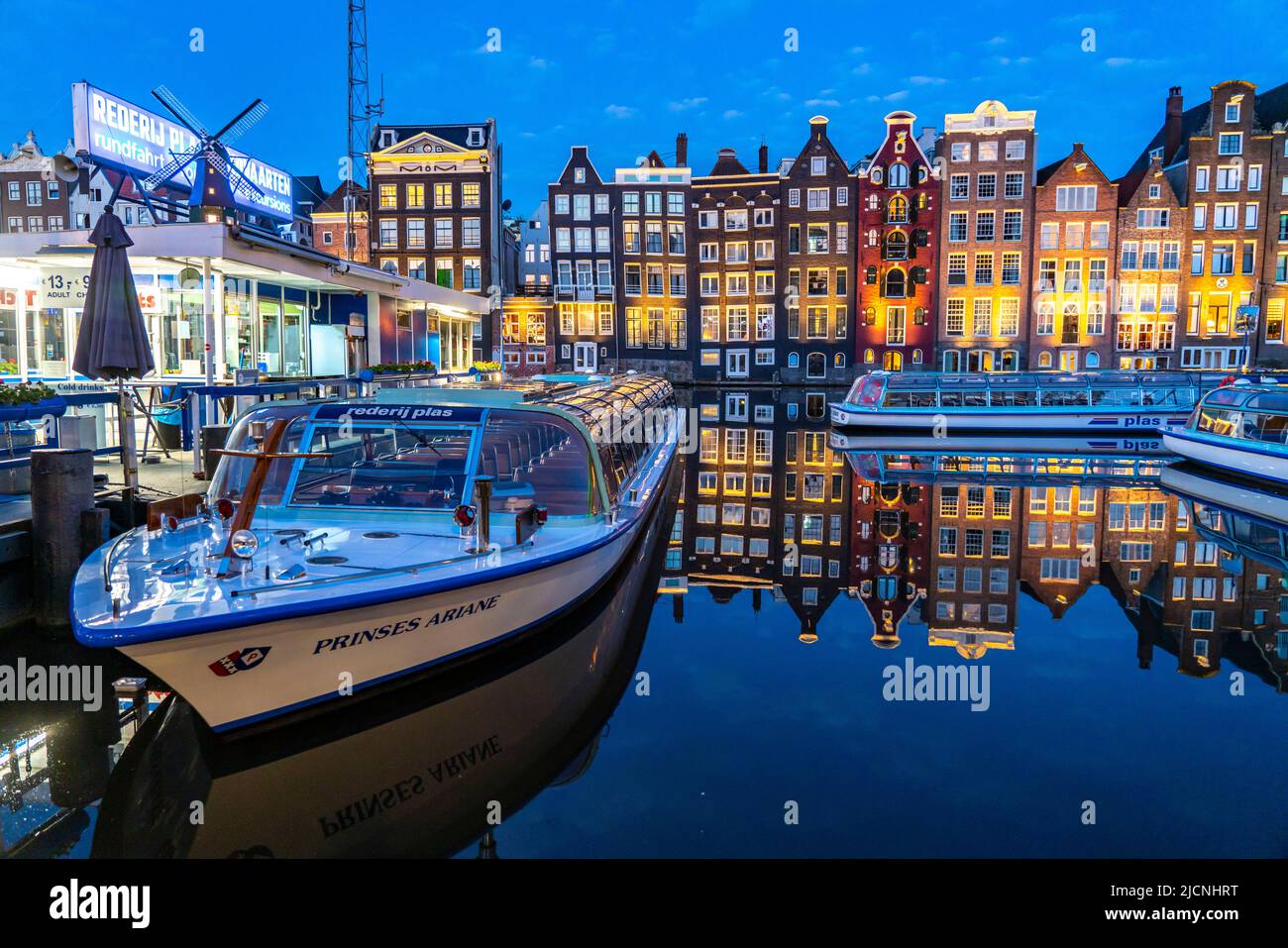 Maisons de canal sur le Damrak, dans le centre de la vieille ville d'Amsterdam, port, point de départ de nombreuses visites de canal, soirée, pays-Bas, Banque D'Images