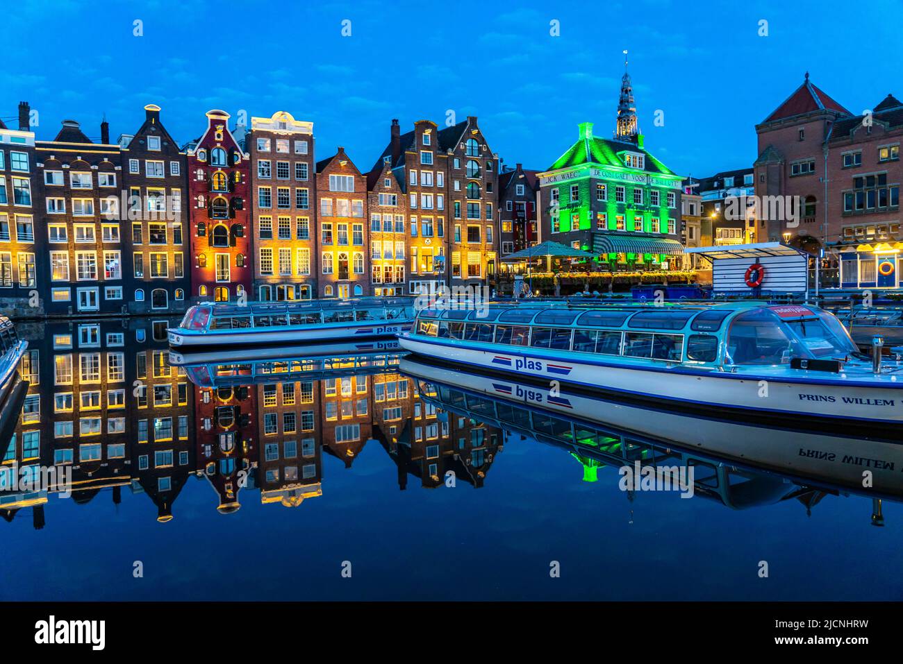 Maisons de canal sur le Damrak, dans le centre de la vieille ville d'Amsterdam, port, point de départ de nombreuses visites de canal, soirée, pays-Bas, Banque D'Images