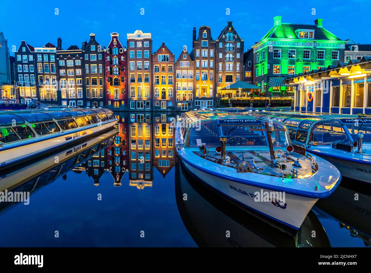 Maisons de canal sur le Damrak, dans le centre de la vieille ville d'Amsterdam, port, point de départ de nombreuses visites de canal, soirée, pays-Bas, Banque D'Images