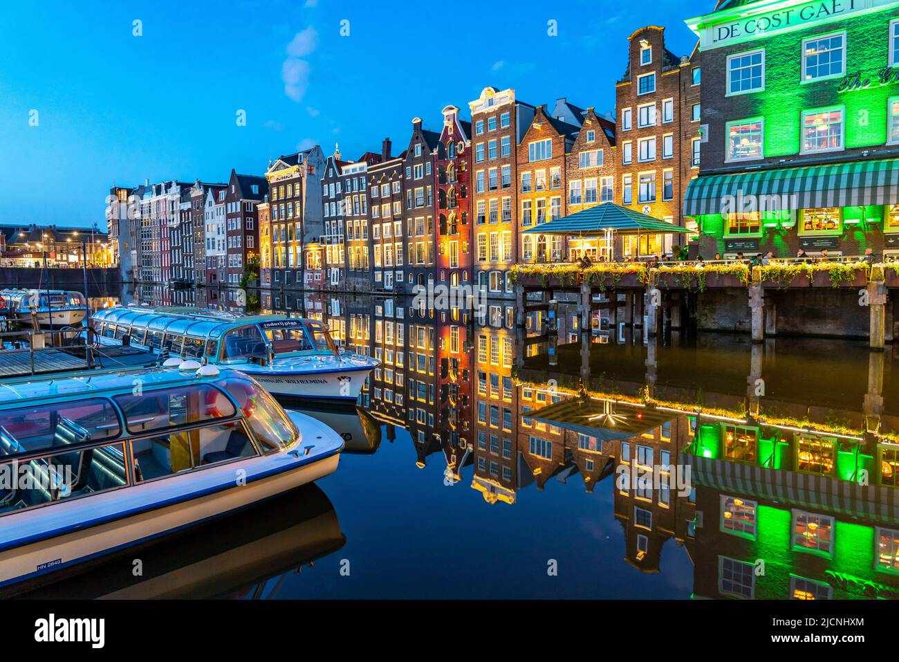 Maisons de canal sur le Damrak, dans le centre de la vieille ville d'Amsterdam, port, point de départ de nombreuses visites de canal, soirée, pays-Bas, Banque D'Images