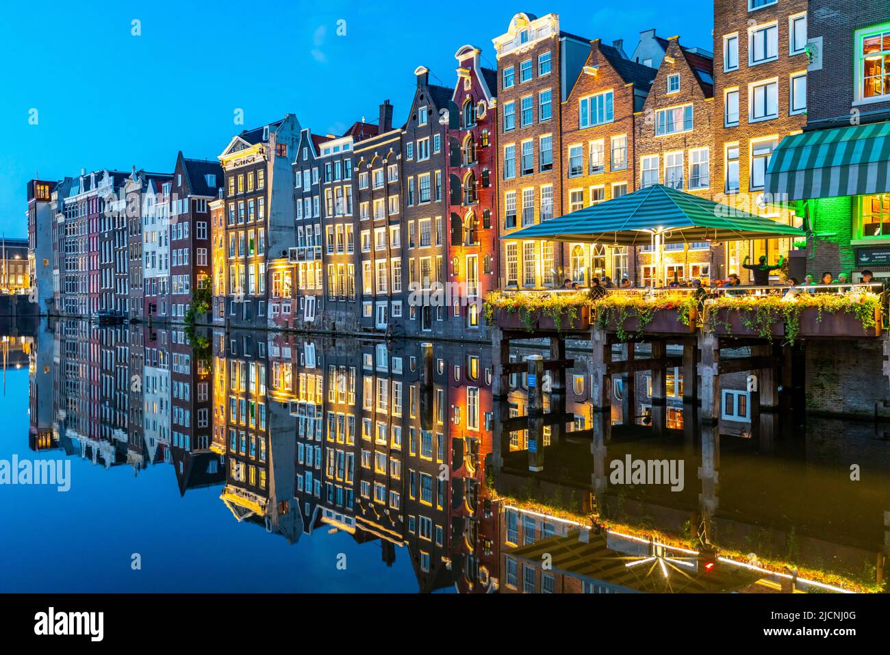 Maisons de canal sur le Damrak, dans le centre de la vieille ville d'Amsterdam, port, point de départ de nombreuses visites de canal, soirée, pays-Bas, Banque D'Images