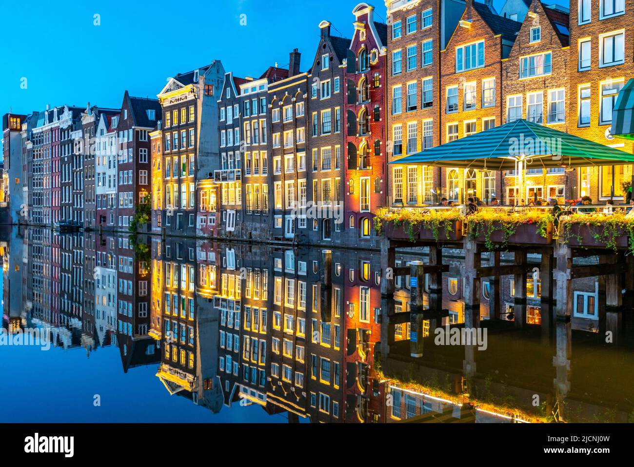 Maisons de canal sur le Damrak, dans le centre de la vieille ville d'Amsterdam, port, point de départ de nombreuses visites de canal, soirée, pays-Bas, Banque D'Images