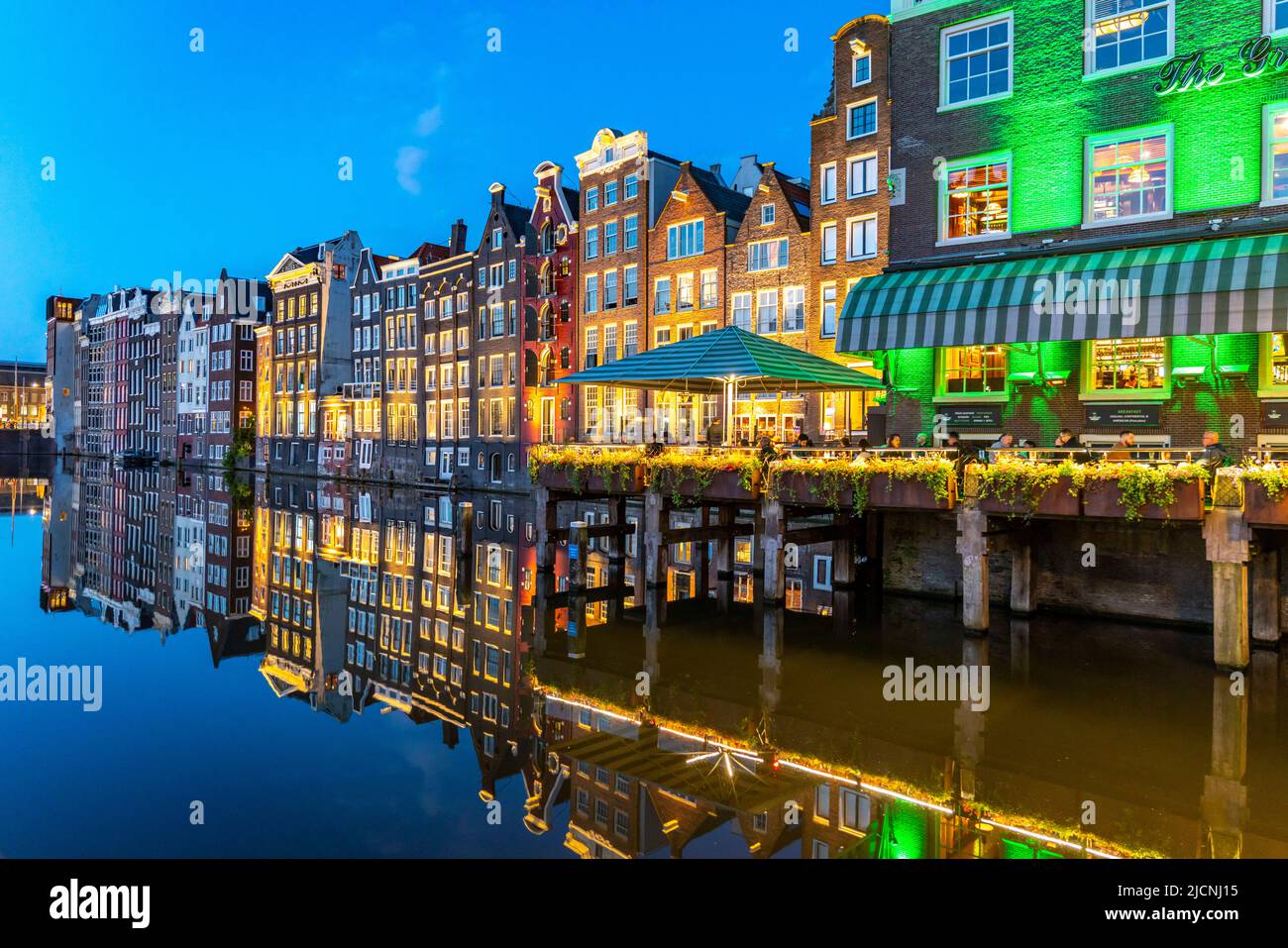 Maisons de canal sur le Damrak, dans le centre de la vieille ville d'Amsterdam, port, point de départ de nombreuses visites de canal, soirée, pays-Bas, Banque D'Images