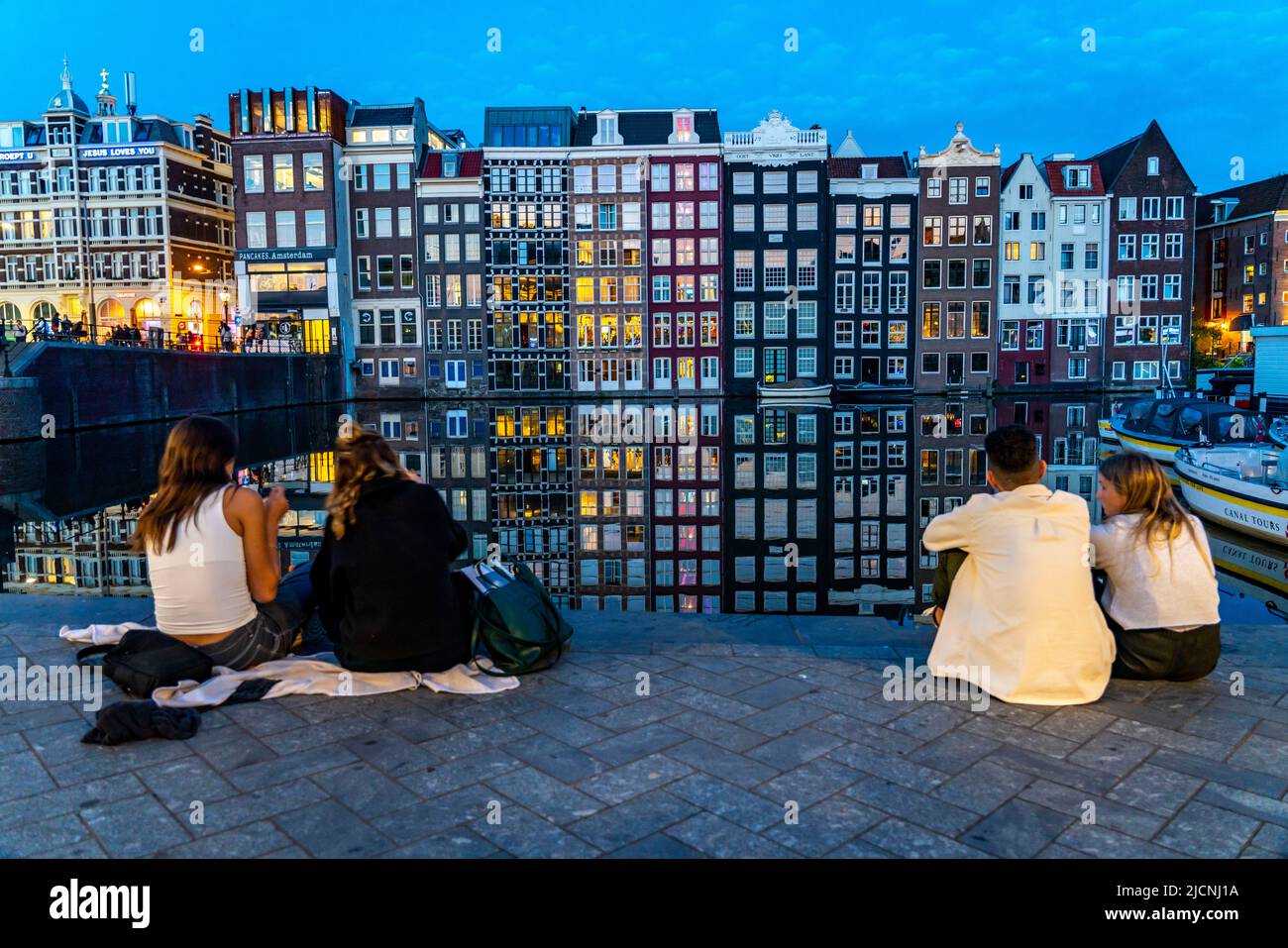 Maisons de canal sur le Damrak, dans le centre de la vieille ville d'Amsterdam, port, point de départ de nombreuses visites de canal, soirée, pays-Bas, Banque D'Images