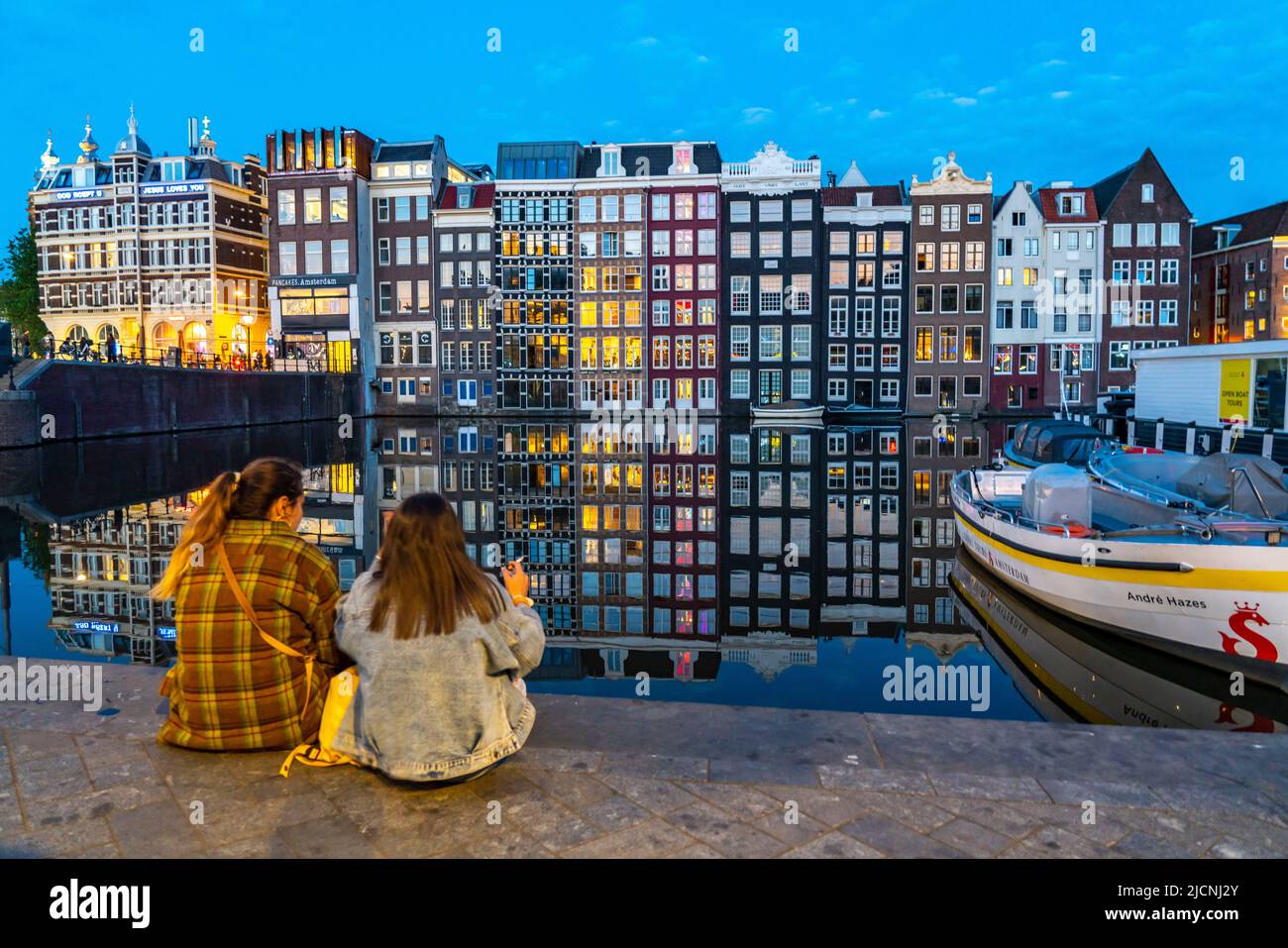 Maisons de canal sur le Damrak, dans le centre de la vieille ville d'Amsterdam, port, point de départ de nombreuses visites de canal, soirée, pays-Bas, Banque D'Images