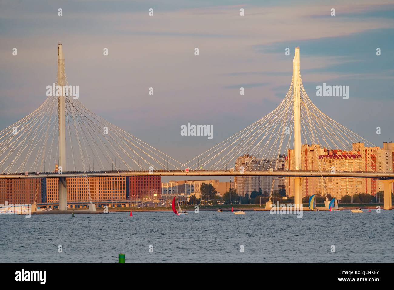 Les bateaux à voile en arrière-plan du nouveau câble sont restés le pont au coucher du soleil Banque D'Images