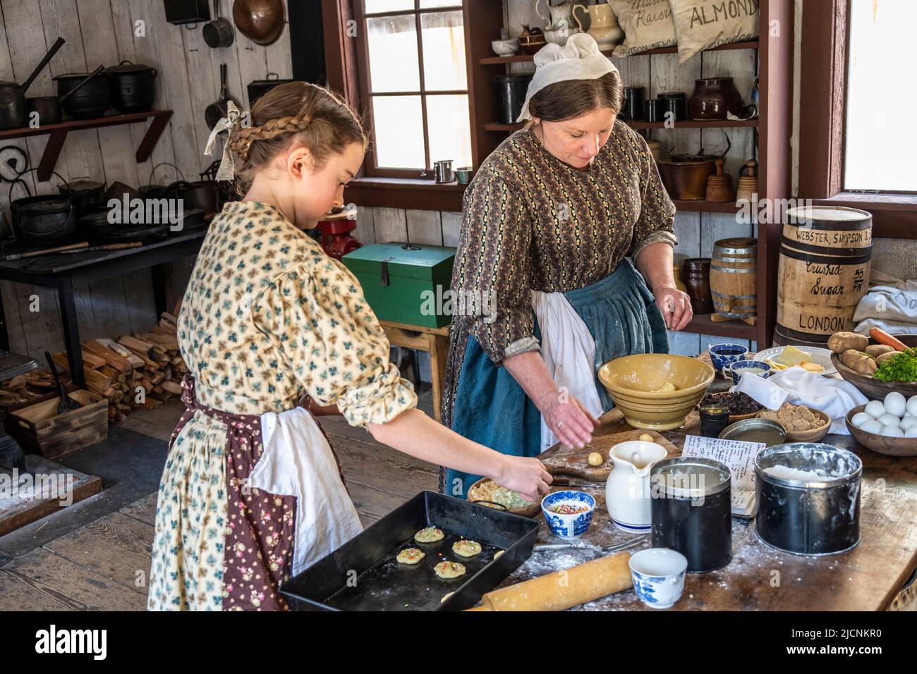 Une fille et une femme qui font des biscuits dans la cuisine du musée historique fort Nisqually Living à Tacoma, Washington Banque D'Images