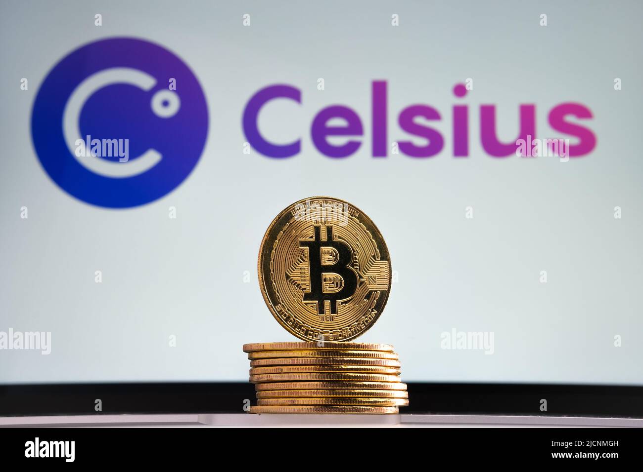 Jetons Bitcoin vus à l'avant et logo de la société de crypto Celsius flou sur l'arrière-plan flou. Stafford, Royaume-Uni, 14 juillet 2022 Banque D'Images