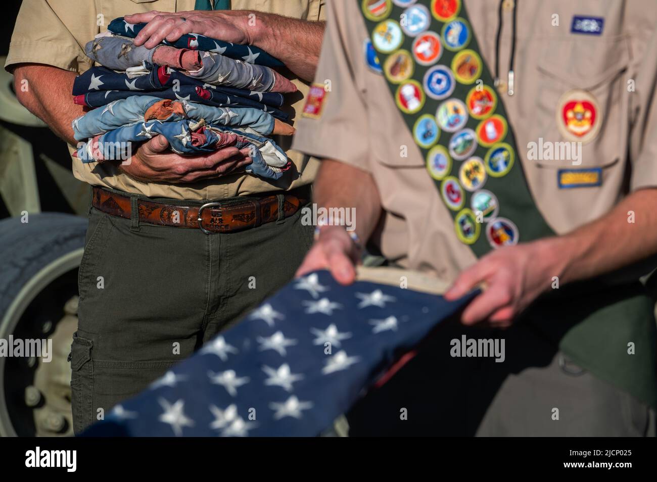 Mt. Top, États-Unis. 14th juin 2022. Un chef scout de garçon détient une pile de drapeaux américains à la retraite tandis qu'un scout remette un drapeau. Le jour du drapeau en Amérique est 14 juin et est un jour destiné à honorer le drapeau. Les drapeaux recueillis tout au long de l'année sont retirés en les brûlant dans un feu bien alimenté. Crédit : SOPA Images Limited/Alamy Live News Banque D'Images