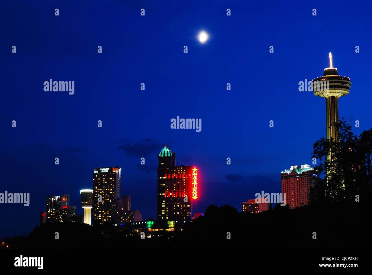 Une pleine lune s'élève au-dessus des hôtels et des tours d'observation qui composent la ligne d'horizon de Niagara Falls, Ontario, Canada Banque D'Images