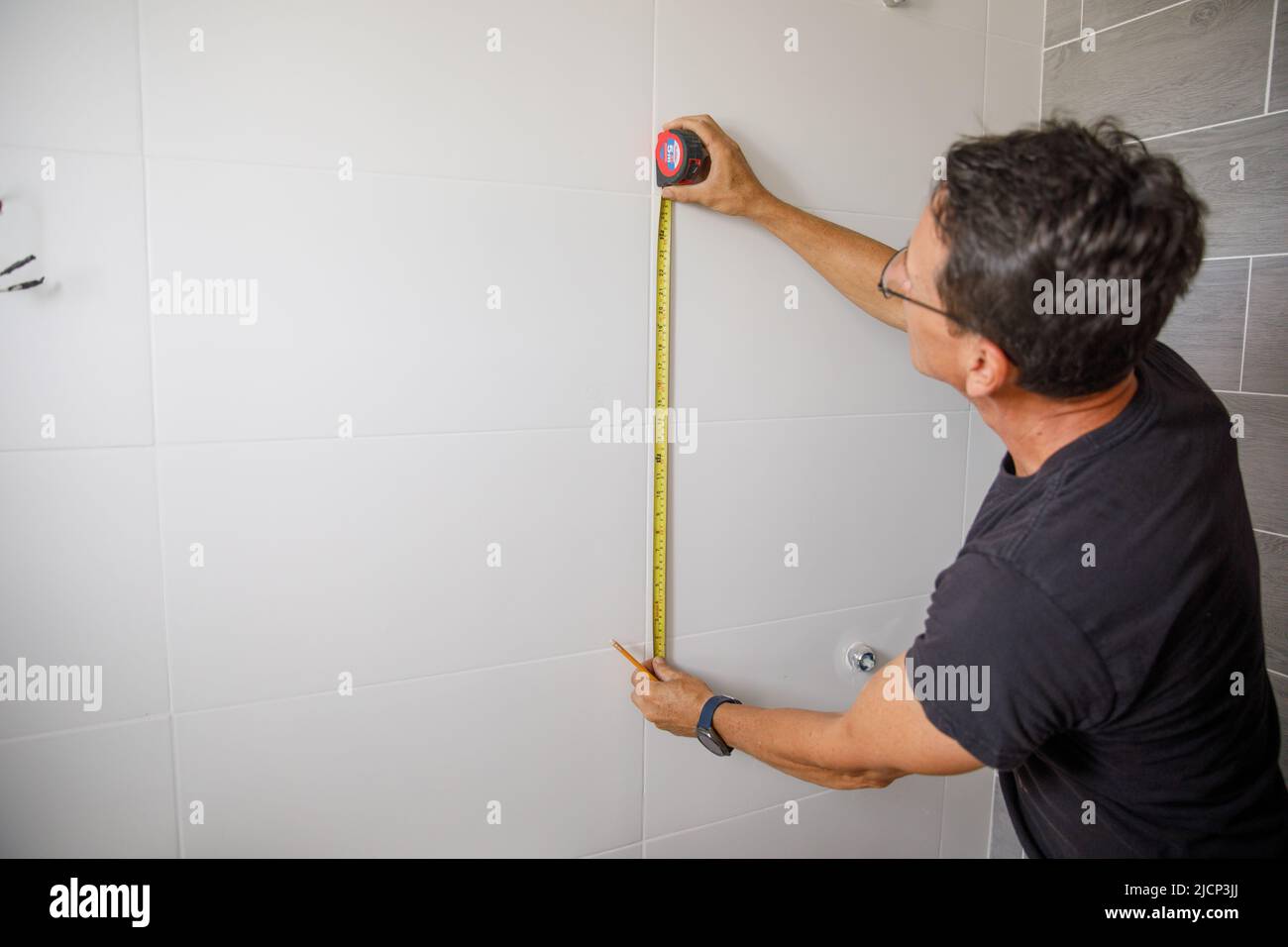 Un homme fait des réparations dans la salle de bains. Banque D'Images
