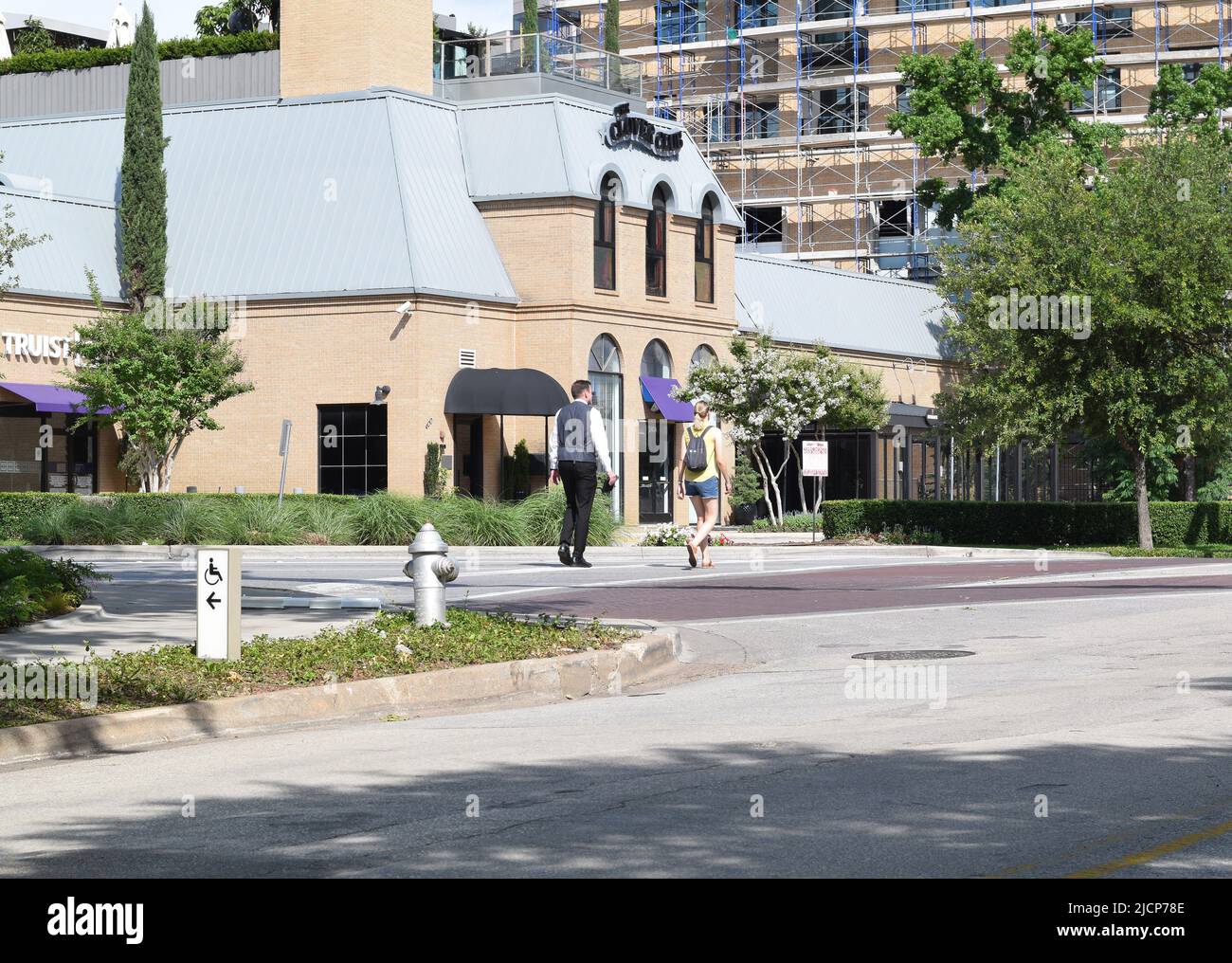 Homme et femme marchant le long de Maple Avenue à Dallas, Texas Banque D'Images