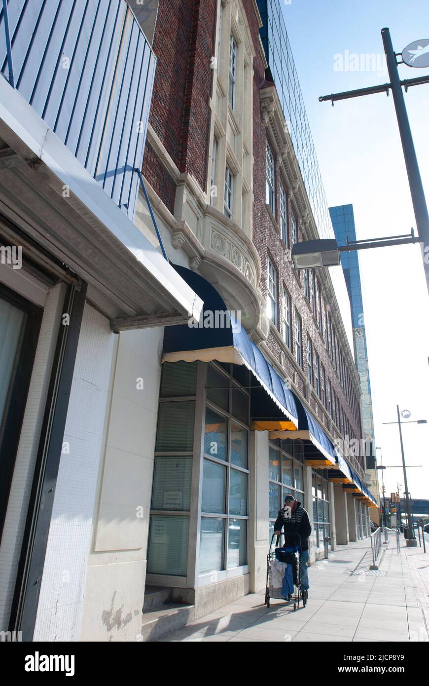 Homme âgé utilisant un marcheur alors qu'il descend un trottoir dans le centre-ville de Dallas, Texas Banque D'Images