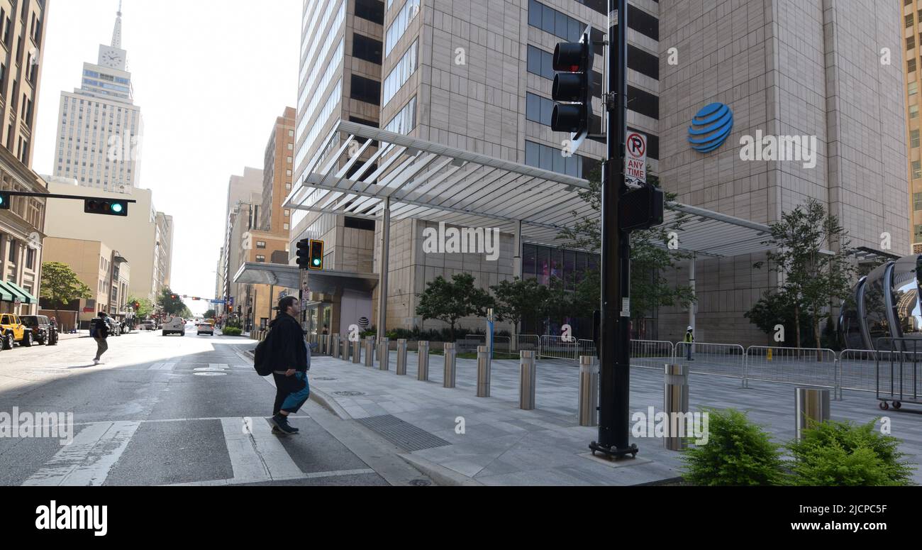 Un homme en surpoids se promenant de l'autre côté de la rue vers le bâtiment ATT dans le centre-ville de Dallas, Texas Banque D'Images