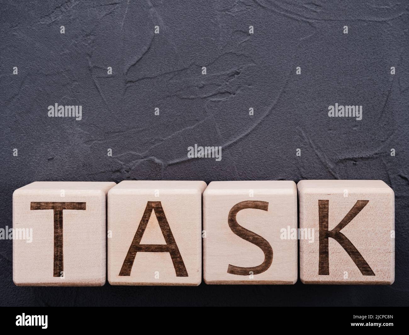 TRAVAIL de mot sur des cubes en bois sur fond de béton gris Banque D'Images