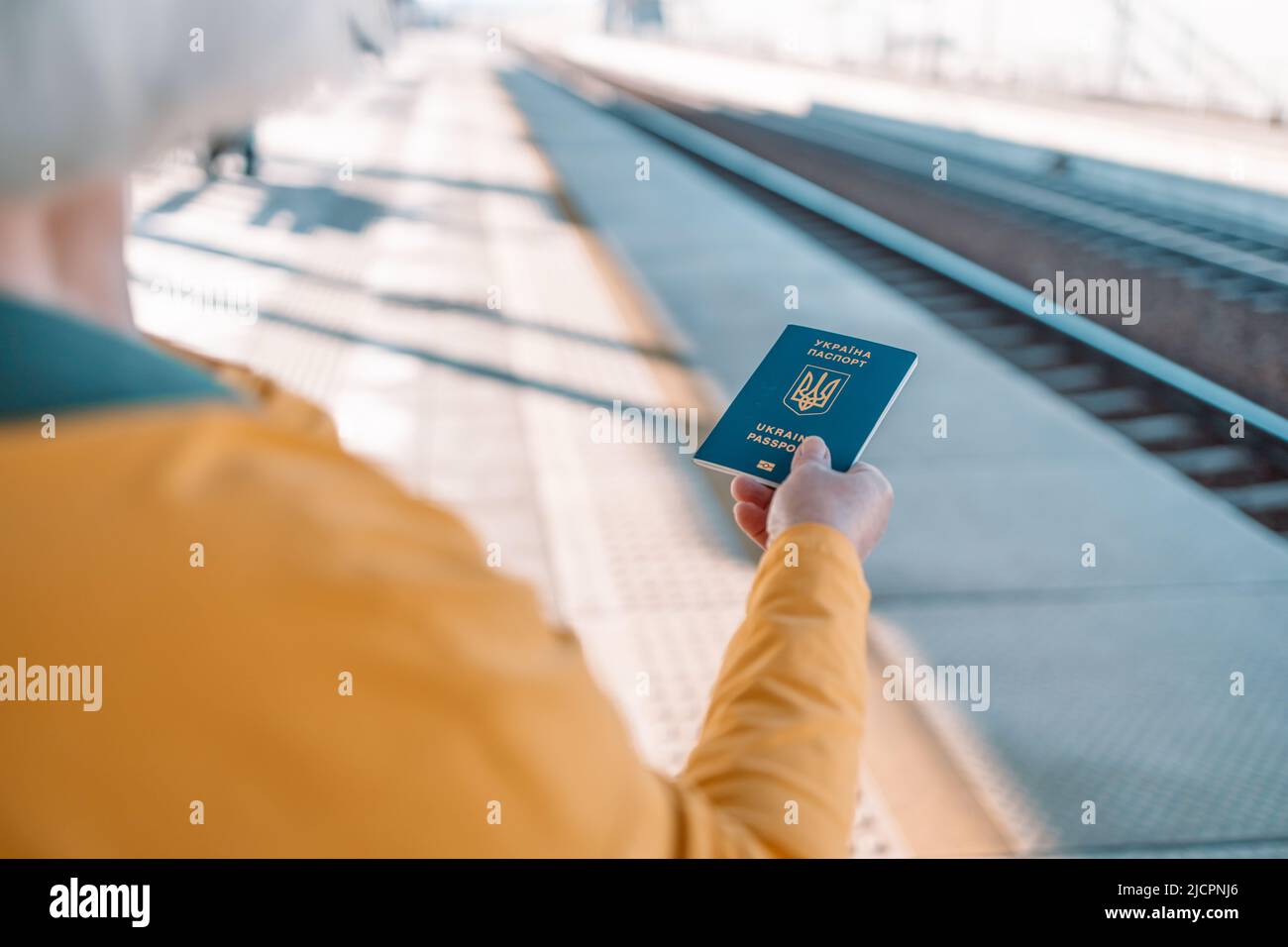 Une femme porte un passeport biométrique ukrainien pour voyager en Europe sans visa à la gare de voyage. Passeport moderne avec puce électronique Banque D'Images