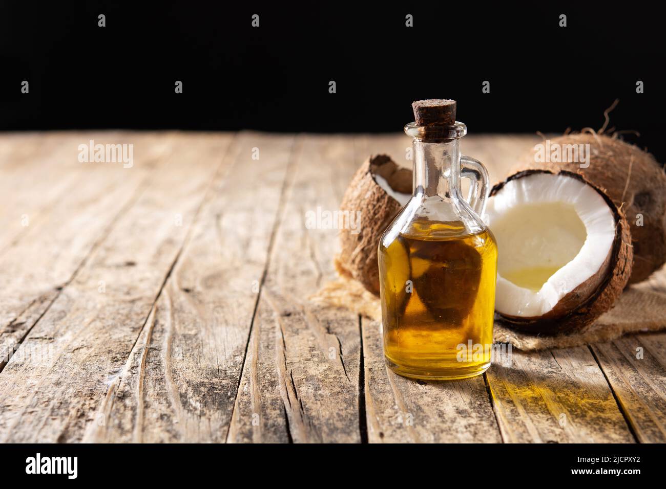 Huile de coco et bouteille d'huile sur une table en bois Banque D'Images