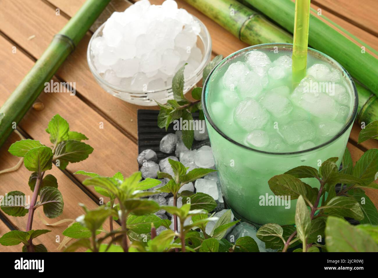 Menthe glacée naturelle sur une table en bois avec de la glace pilée avec des feuilles et plante autour. Vue en hauteur. Composition horizontale. Banque D'Images